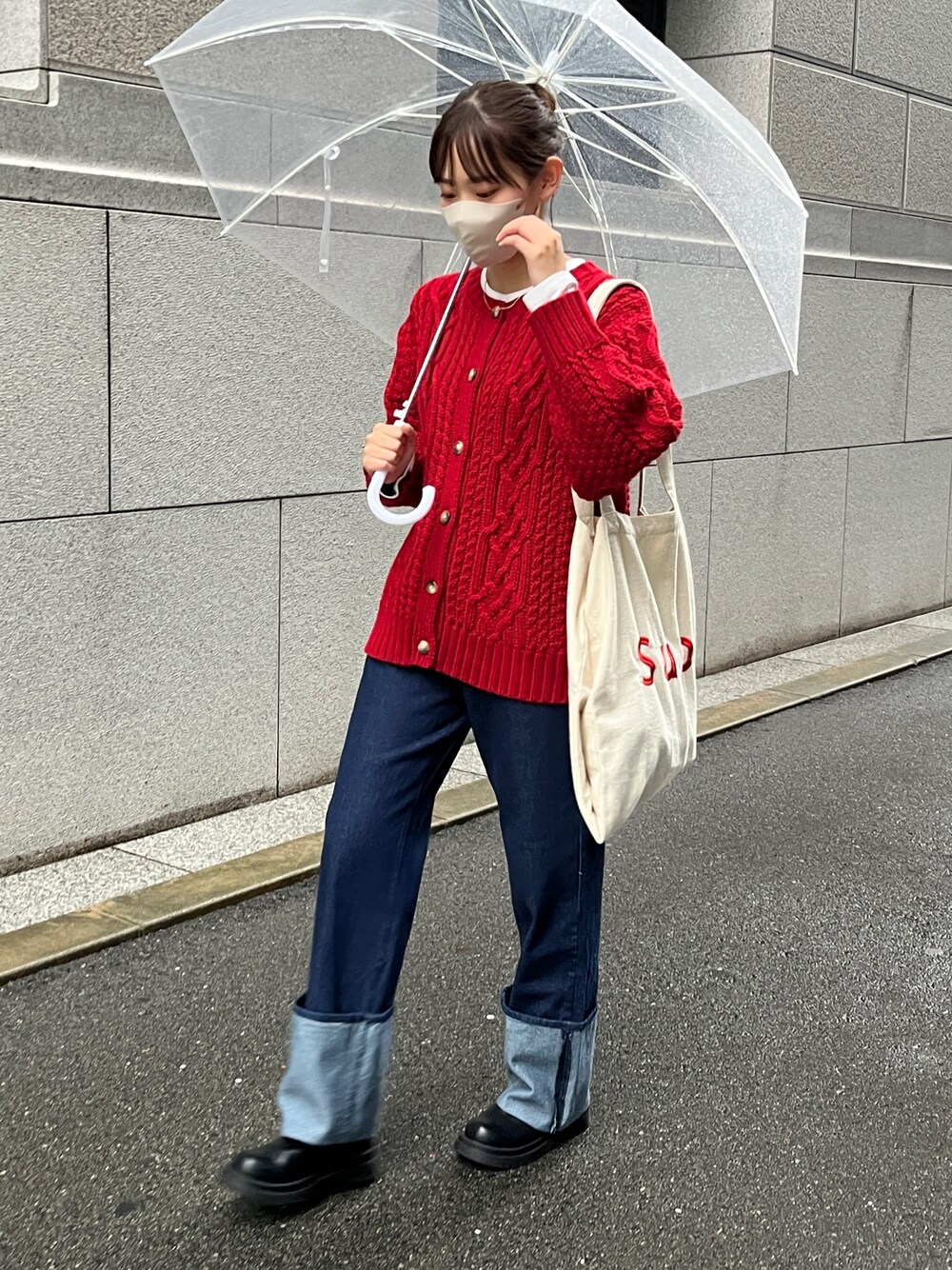 レッド系のカーディガン/ボレロ、ブルー系のデニムパンツ、ホワイト系のトートバッグを着用したレディースの秋コーディネートの1枚目の写真