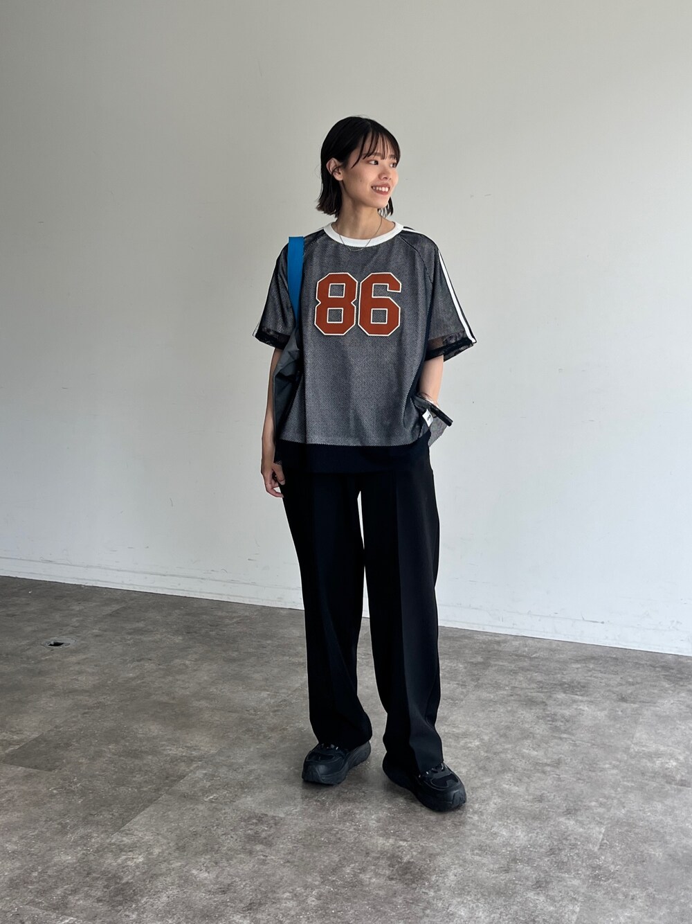 ブルー系のTシャツ/カットソー、ブラック系のスラックスを着用したレディースの夏コーディネートの1枚目の写真