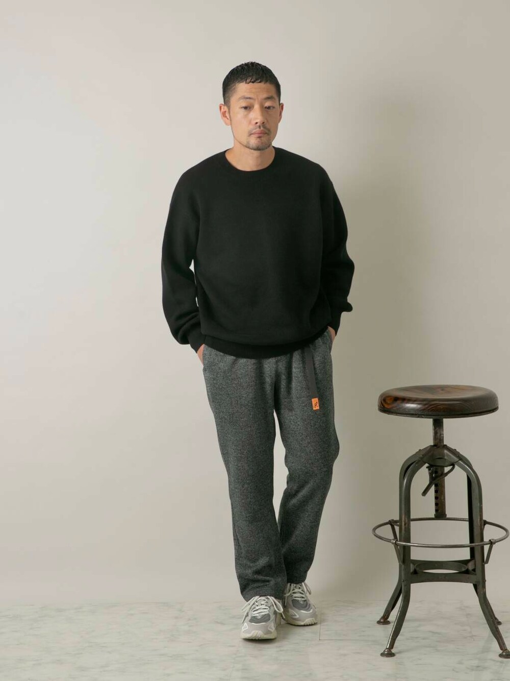 グレー系のその他パンツ、ブラック系のニット/セーターを着用したメンズの秋コーディネートの1枚目の写真