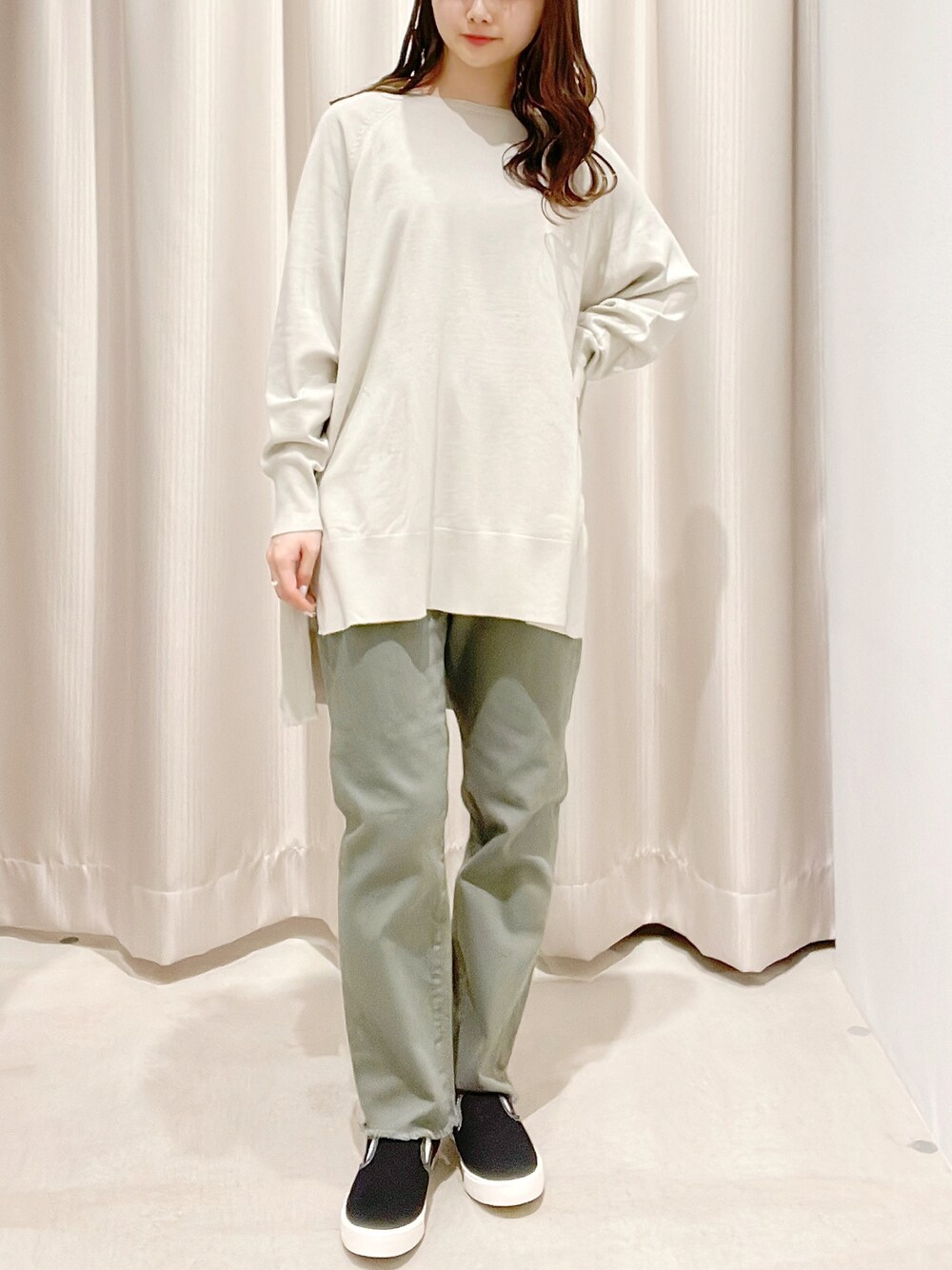 グレー系のニット/セーター、グリーン系のデニムパンツ、ブラック系のスリッポンを着用したレディースの春コーディネートの1枚目の写真