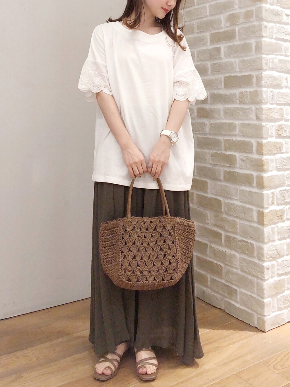 ホワイト系のTシャツ/カットソー、ブラウン系のスカート、ブラウン系のサンダルを着用したレディースの秋コーディネートの1枚目の写真