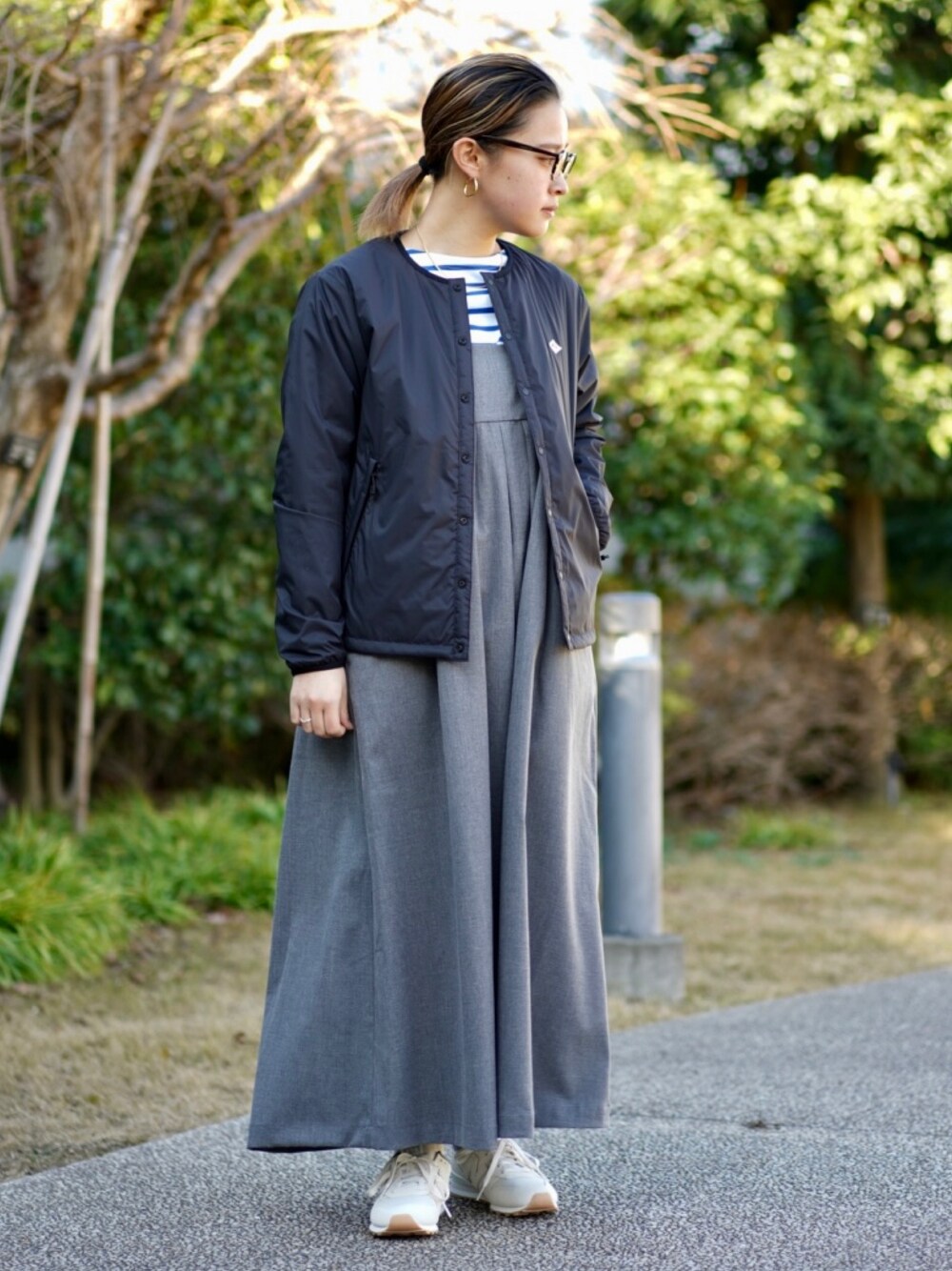 ブラック系のブルゾン、グレー系のジャンパースカート、ブルー系のTシャツ/カットソーを着用したレディースの冬コーディネートの1枚目の写真