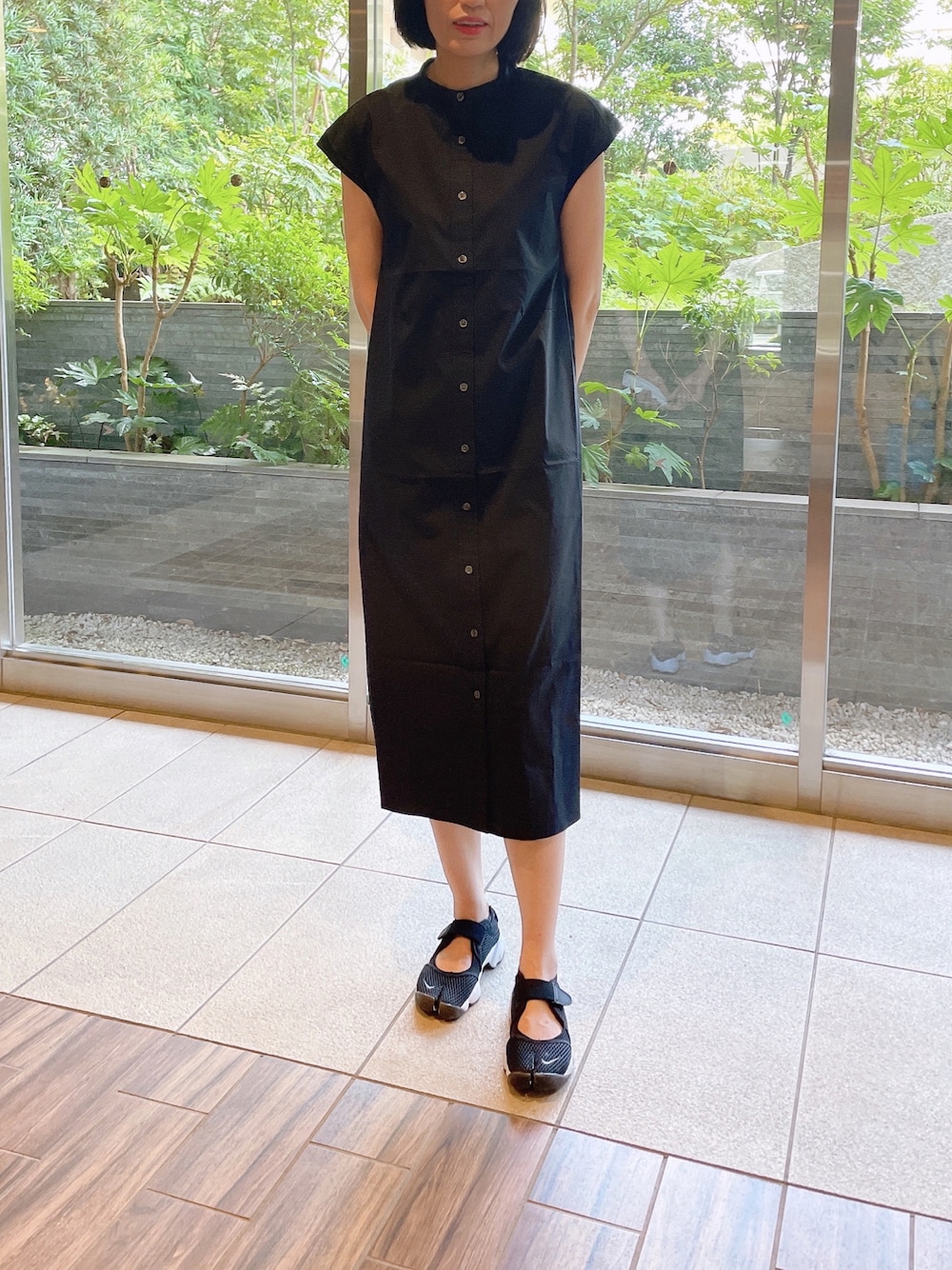 ブラック系のワンピースを着用したレディースの夏コーディネートの1枚目の写真