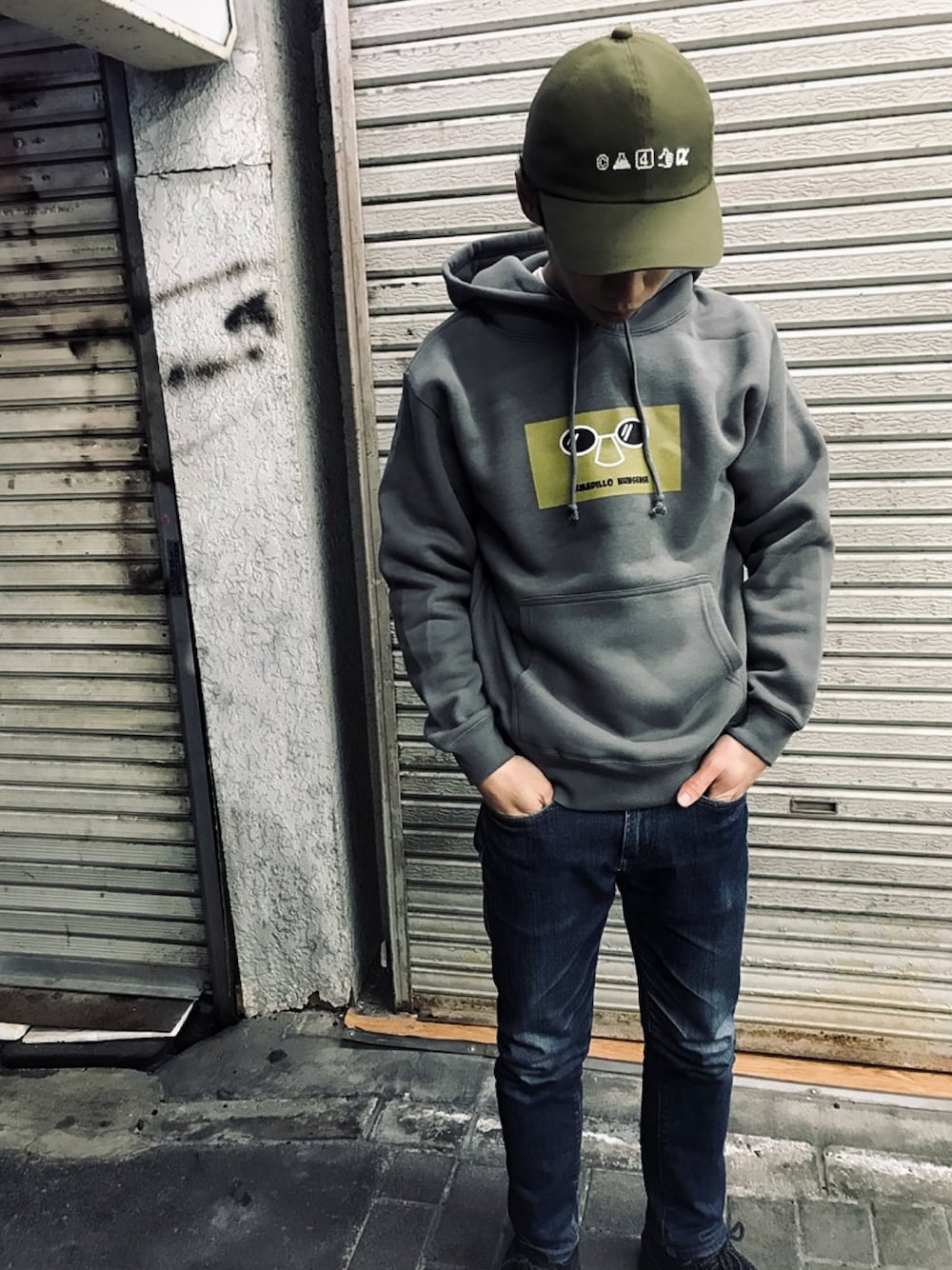 「CA4LA、ARMADILLO NUNSENSE、パーカー、プルオーバー、ワイドパンツ、プルオーバーパーカー、パーカー グレー、デニムパンツ、パーカーコーデ、パーカースタイル、キャップコーデ、キャップ、オリーブ、帽子、帽子コーデ」｜「CA4LAのDOCOMO x CA4LA CAP（キャップ、グリーン系）」を使った、福®︎さん（メンズ・172cm）の冬コーディネートの1枚目の写真