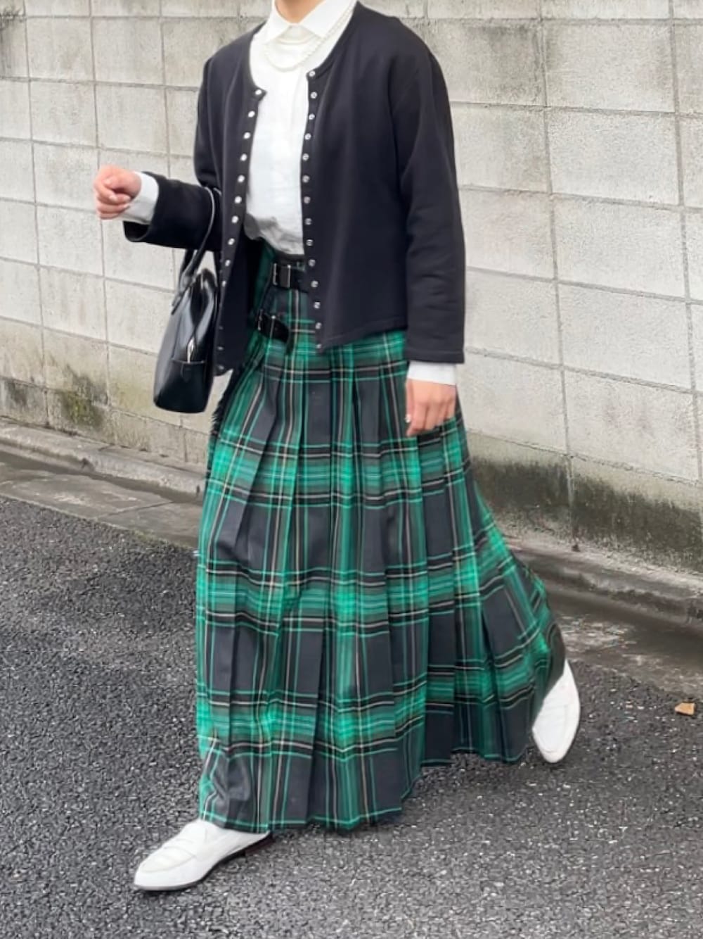 ブラック系のカーディガン/ボレロ、ブラック系のボストンバッグ、グリーン系のスカートを着用したレディースの秋コーディネートの1枚目の写真