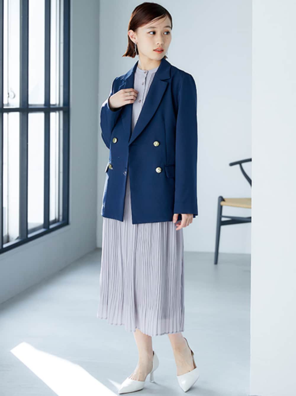 ブルー系のテーラードジャケット、グレー系のワンピースを着用したレディースの春コーディネートの1枚目の写真