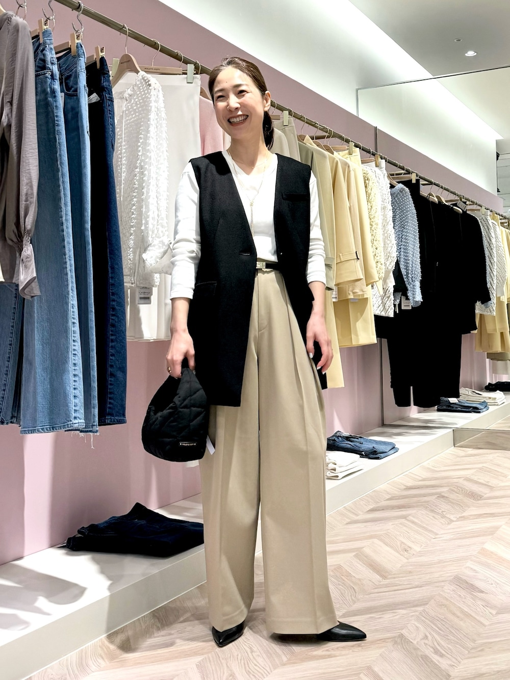 グリーン系のその他パンツ、ホワイト系のTシャツ/カットソー、ブラック系のベストを着用したレディースの春コーディネートの1枚目の写真