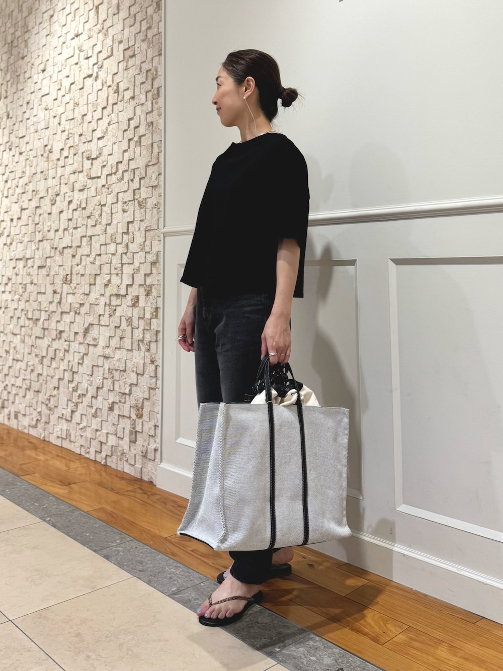 ブラック系のTシャツ/カットソー、ホワイト系のショルダーバッグ、ブラック系のデニムパンツを着用したレディースの夏コーディネートの1枚目の写真