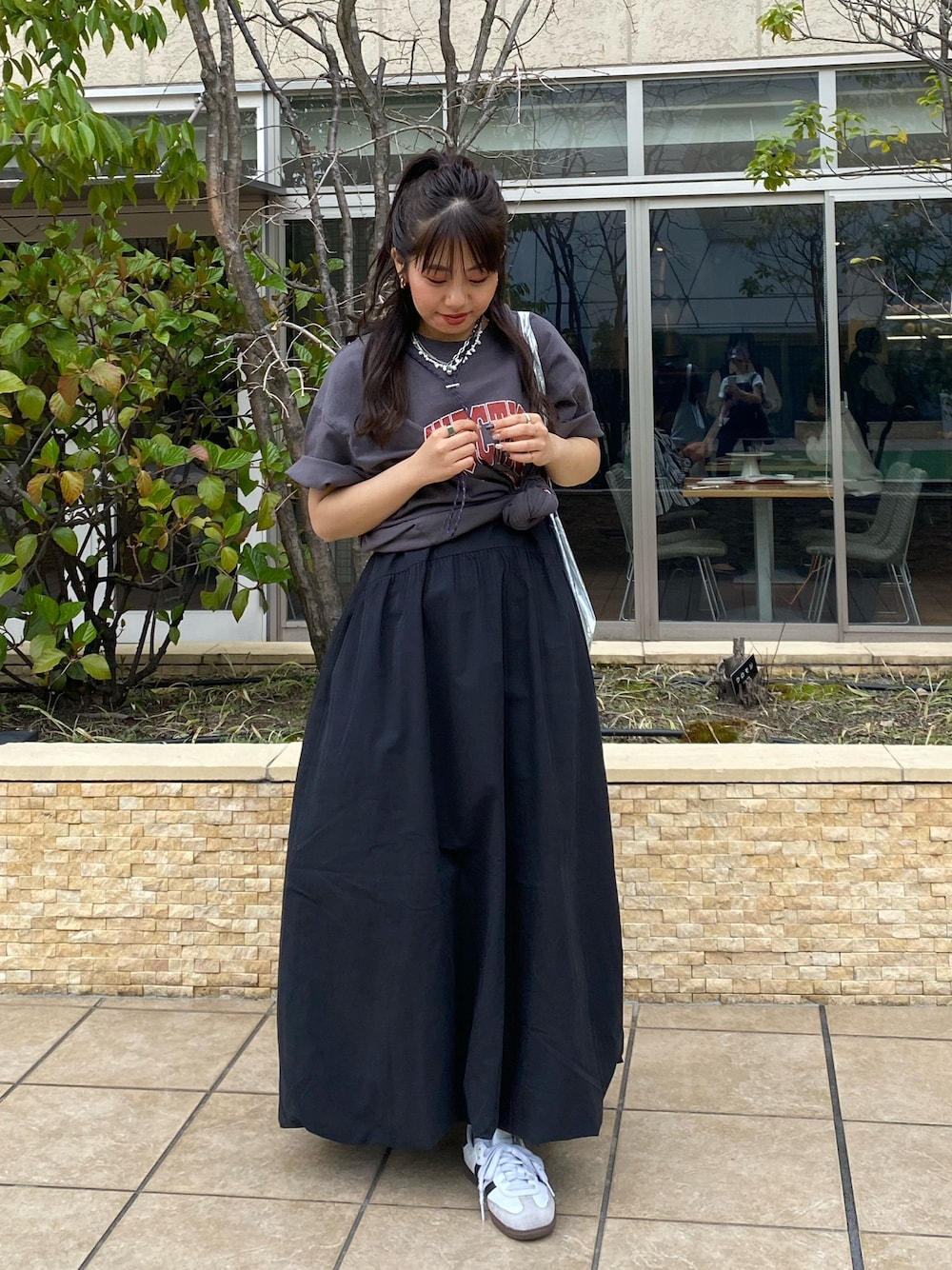 グレー系のTシャツ/カットソー、ブラック系のワンピースを着用したレディースの春コーディネートの1枚目の写真