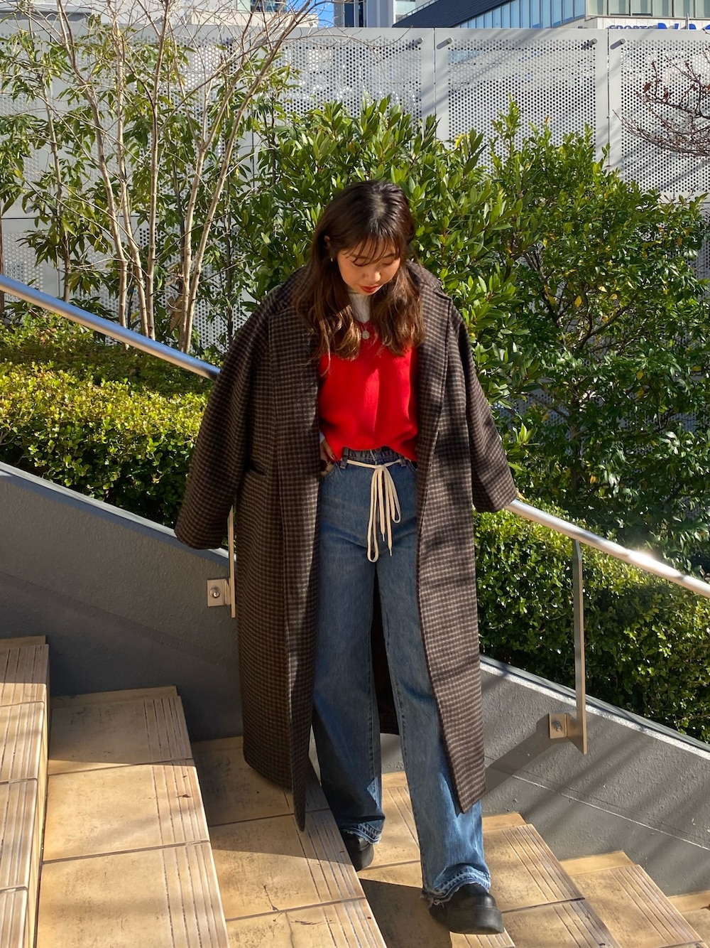 その他のチェスターコート、ブルー系のデニムパンツ、レッド系のニット/セーターを着用したレディースの冬コーディネートの1枚目の写真