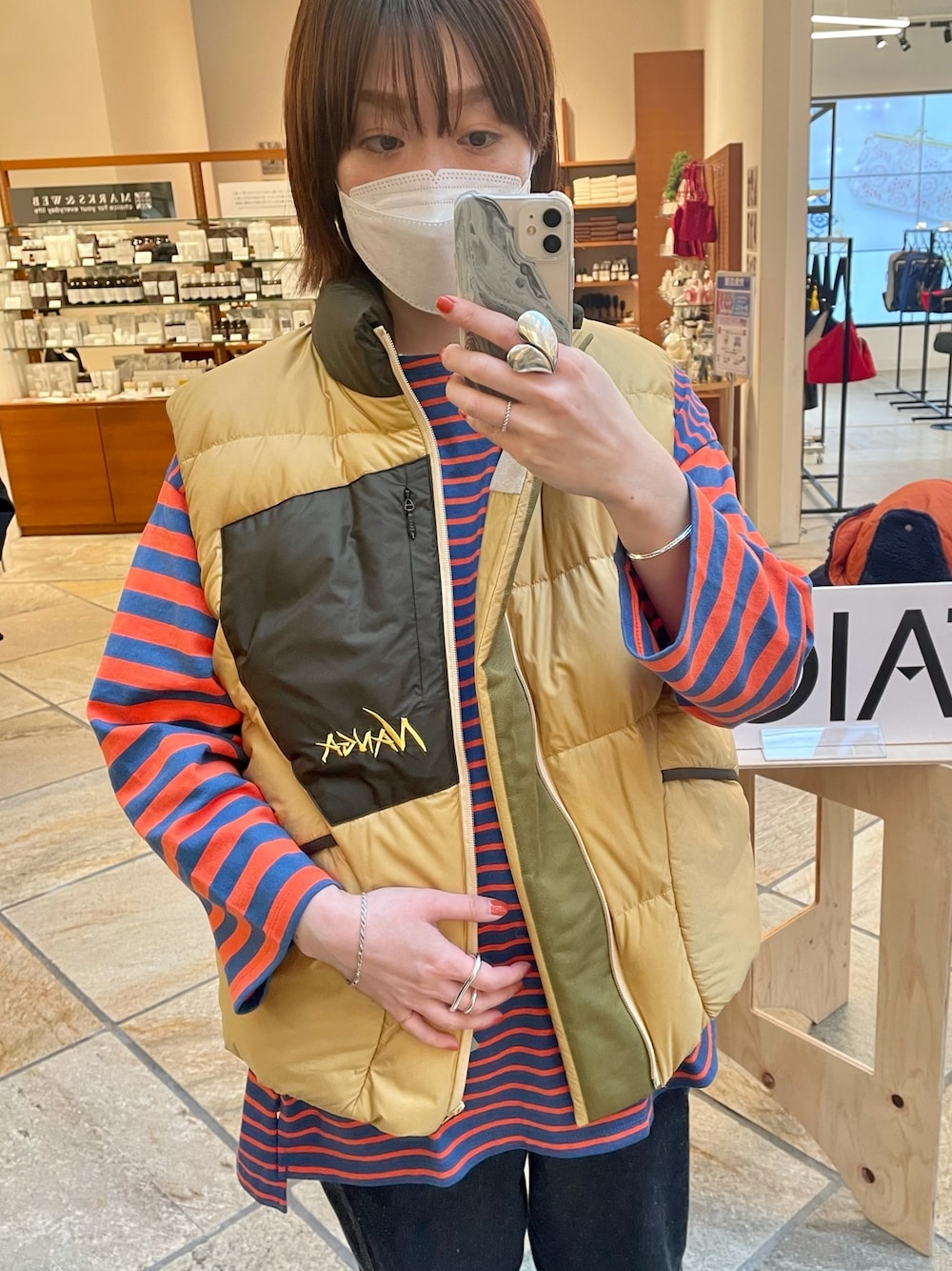 ブラック系のTシャツ/カットソー、ベージュ系のダウンベスト、シルバー系のリングを着用したレディースの冬コーディネートの1枚目の写真