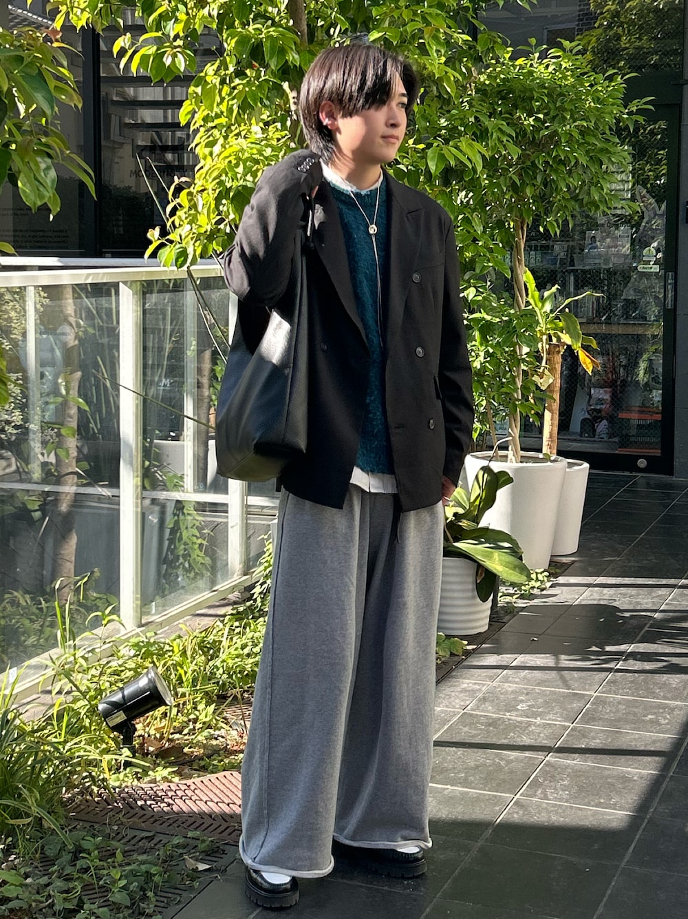 ブラック系のテーラードジャケット、ブラック系のローファー、ブルー系のニット/セーターを着用したメンズの秋コーディネートの1枚目の写真