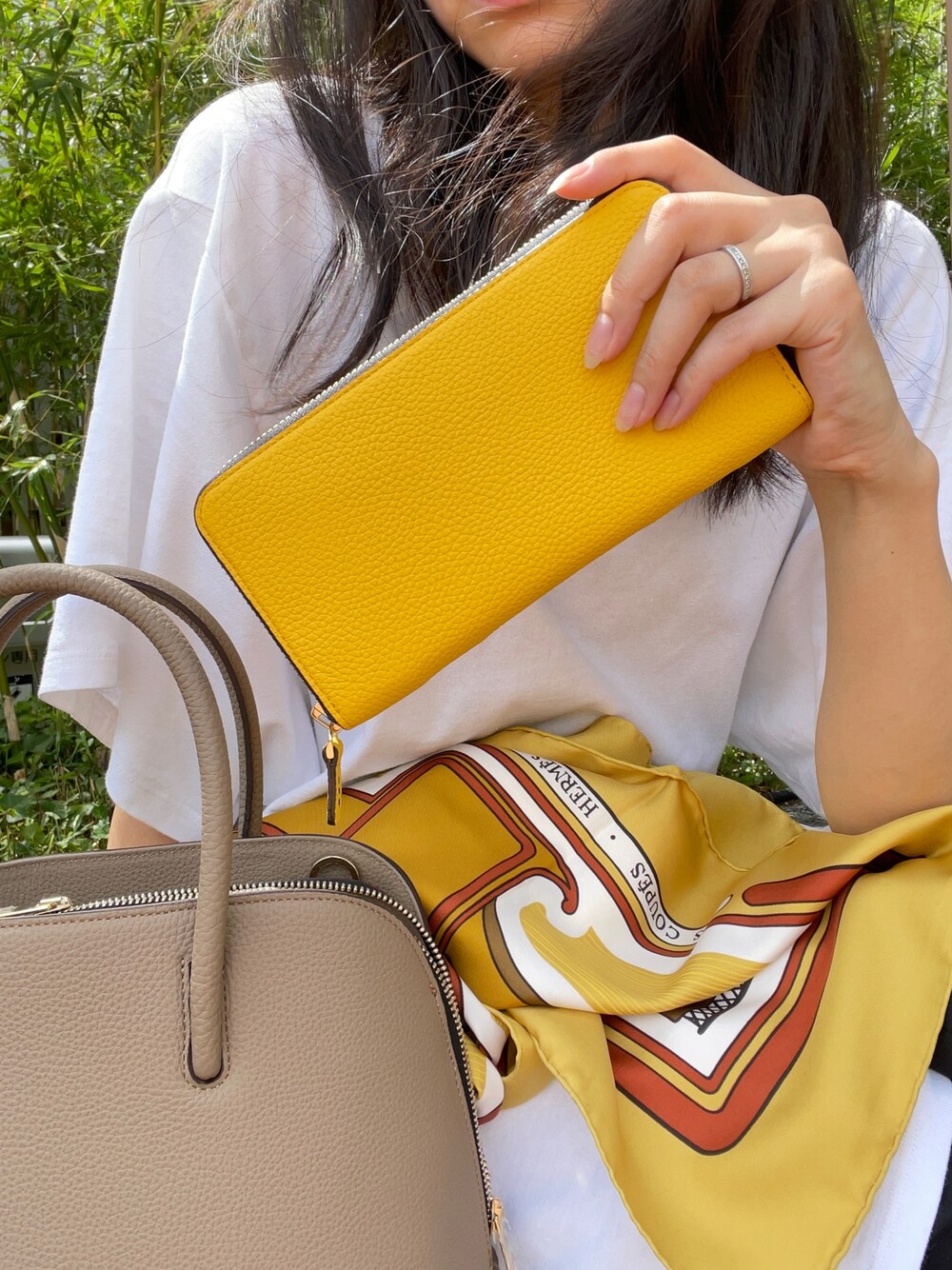 ベージュ系のボストンバッグ、イエロー系の財布を着用したレディースの秋コーディネートの1枚目の写真