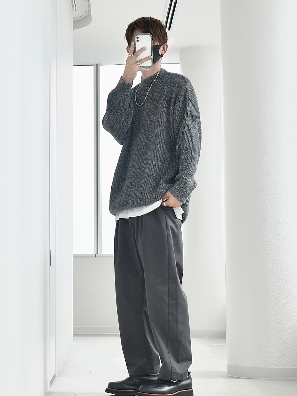 グレー系のニット/セーター、ホワイト系のTシャツ/カットソー、ブラック系のドレスシューズを着用したメンズの秋コーディネートの1枚目の写真