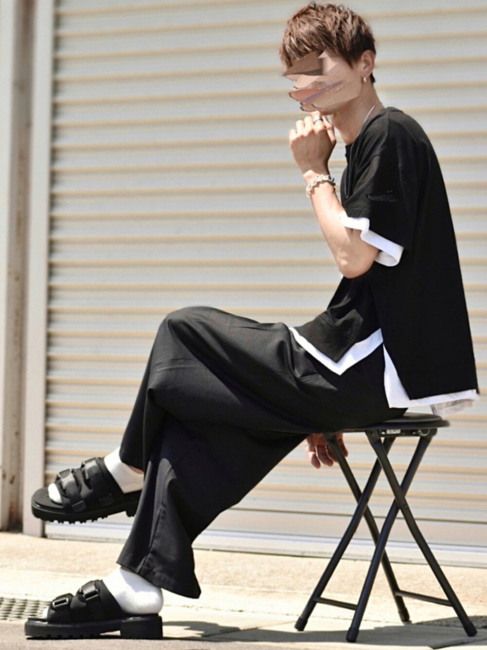 ブラック系のTシャツ/カットソー、ブラック系のスラックス、ブラック系のサンダルを着用したメンズの夏コーディネートの1枚目の写真