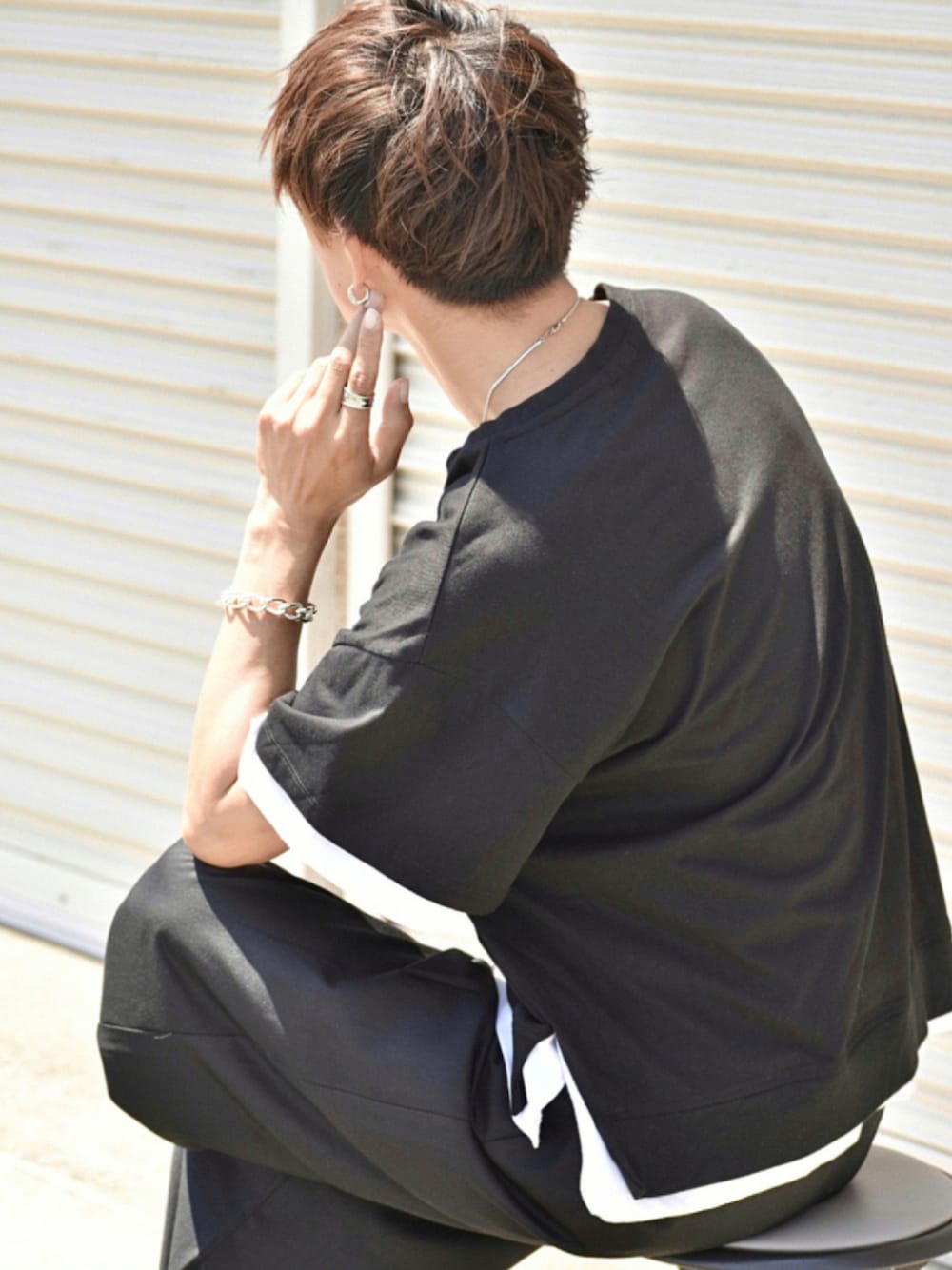 ブラック系のTシャツ/カットソー、ブラック系のスラックス、ブラック系のサンダルを着用したメンズの夏コーディネートの1枚目の写真