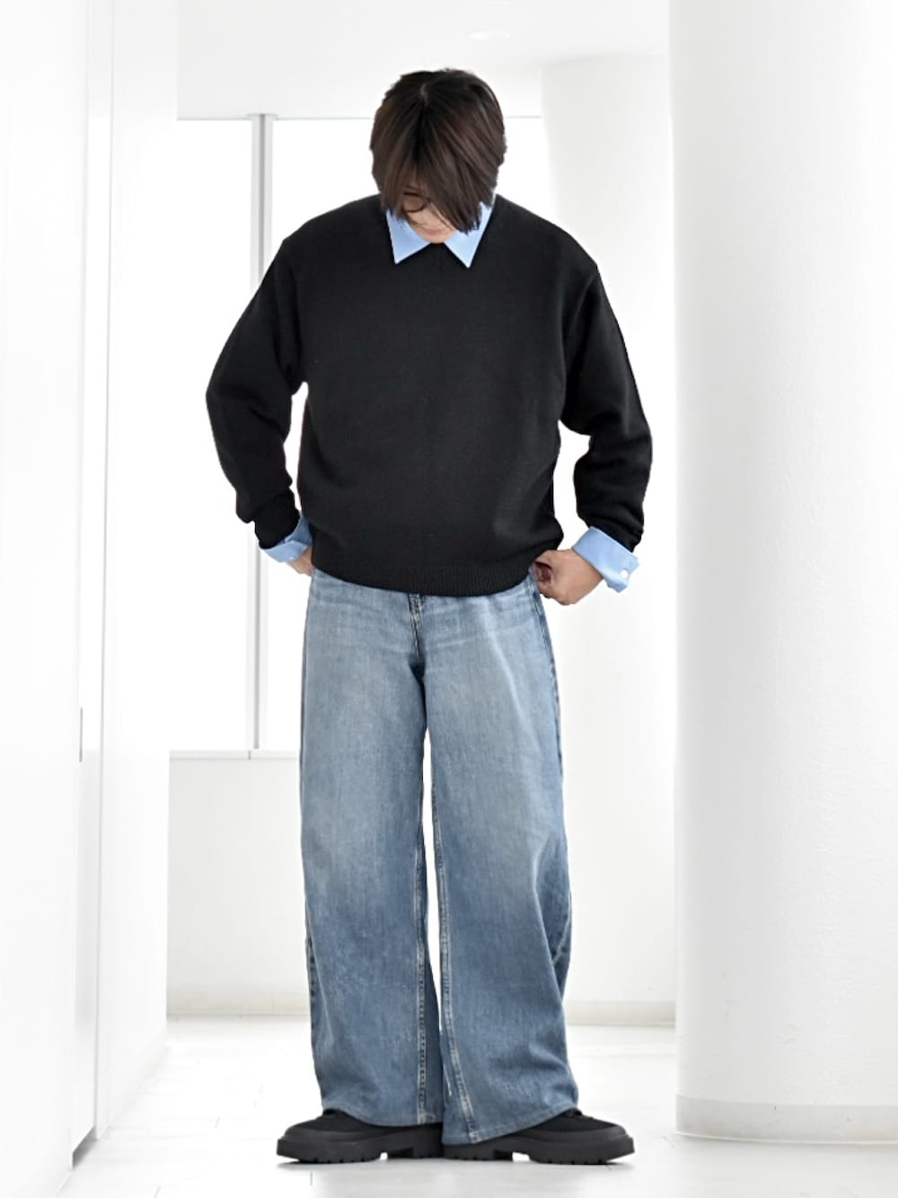 ブルー系のシャツ/ブラウス、ブラック系のニット/セーター、ブルー系のデニムパンツを着用したメンズの秋コーディネートの1枚目の写真