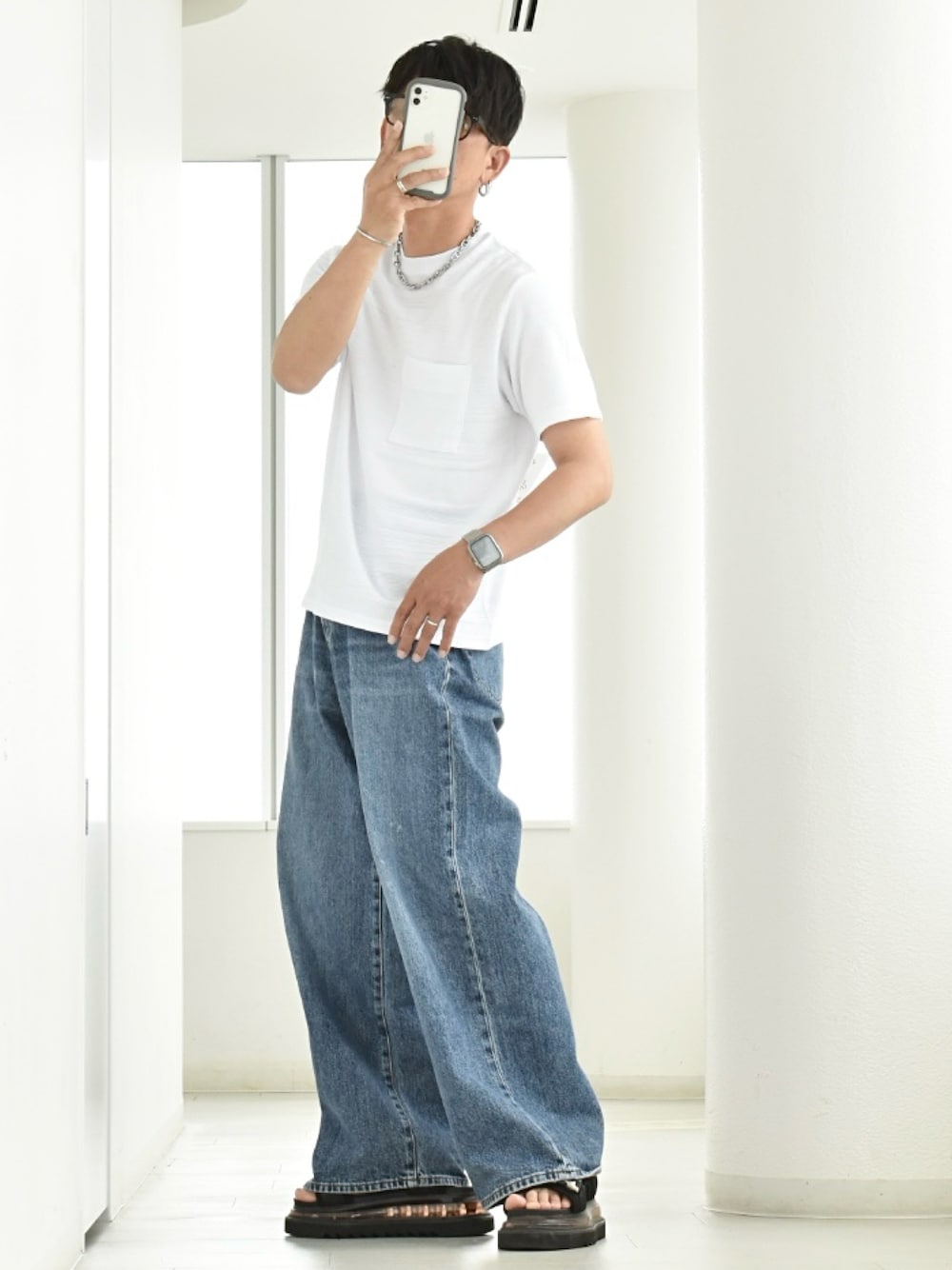 ホワイト系のTシャツ/カットソー、ブラック系のサンダル、ブルー系のデニムパンツを着用したメンズの夏コーディネートの1枚目の写真