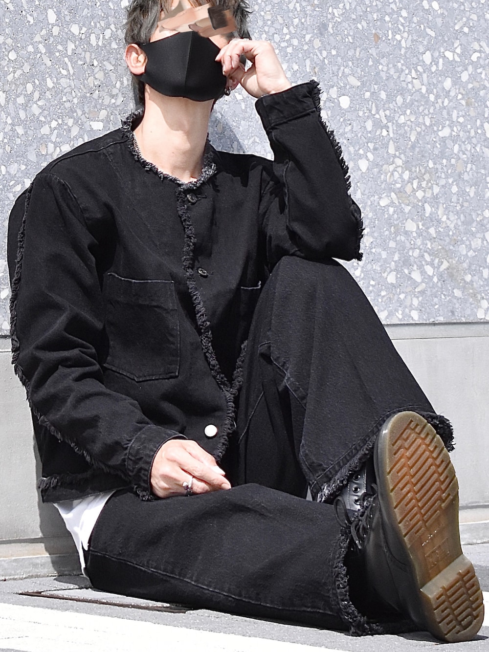 ブラック系のデニムジャケット、ブラック系のデニムパンツ、ブラック系のブーツを着用したメンズの春コーディネートの1枚目の写真
