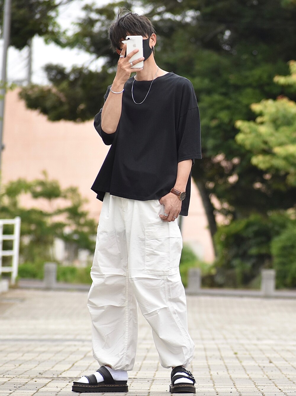ホワイト系のデニムパンツ、ブラック系のTシャツ/カットソー、ブラック系のサンダルを着用したメンズの夏コーディネートの1枚目の写真