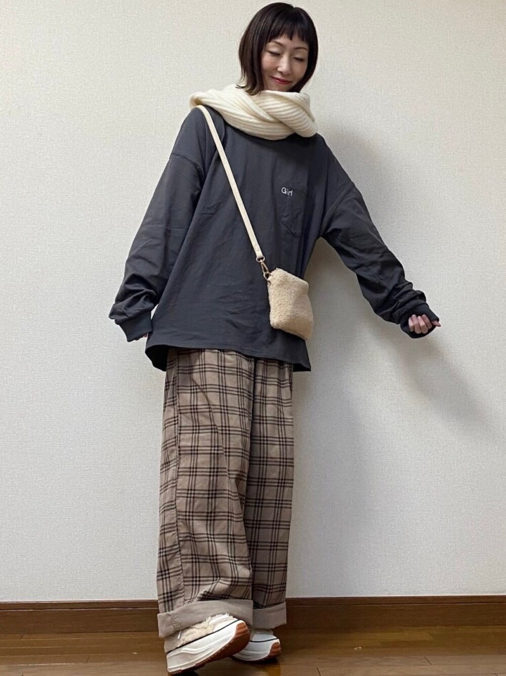 ブラック系のTシャツ/カットソー、ベージュ系のバッグ、ブラウン系のパンツを着用したレディースの冬コーディネートの1枚目の写真