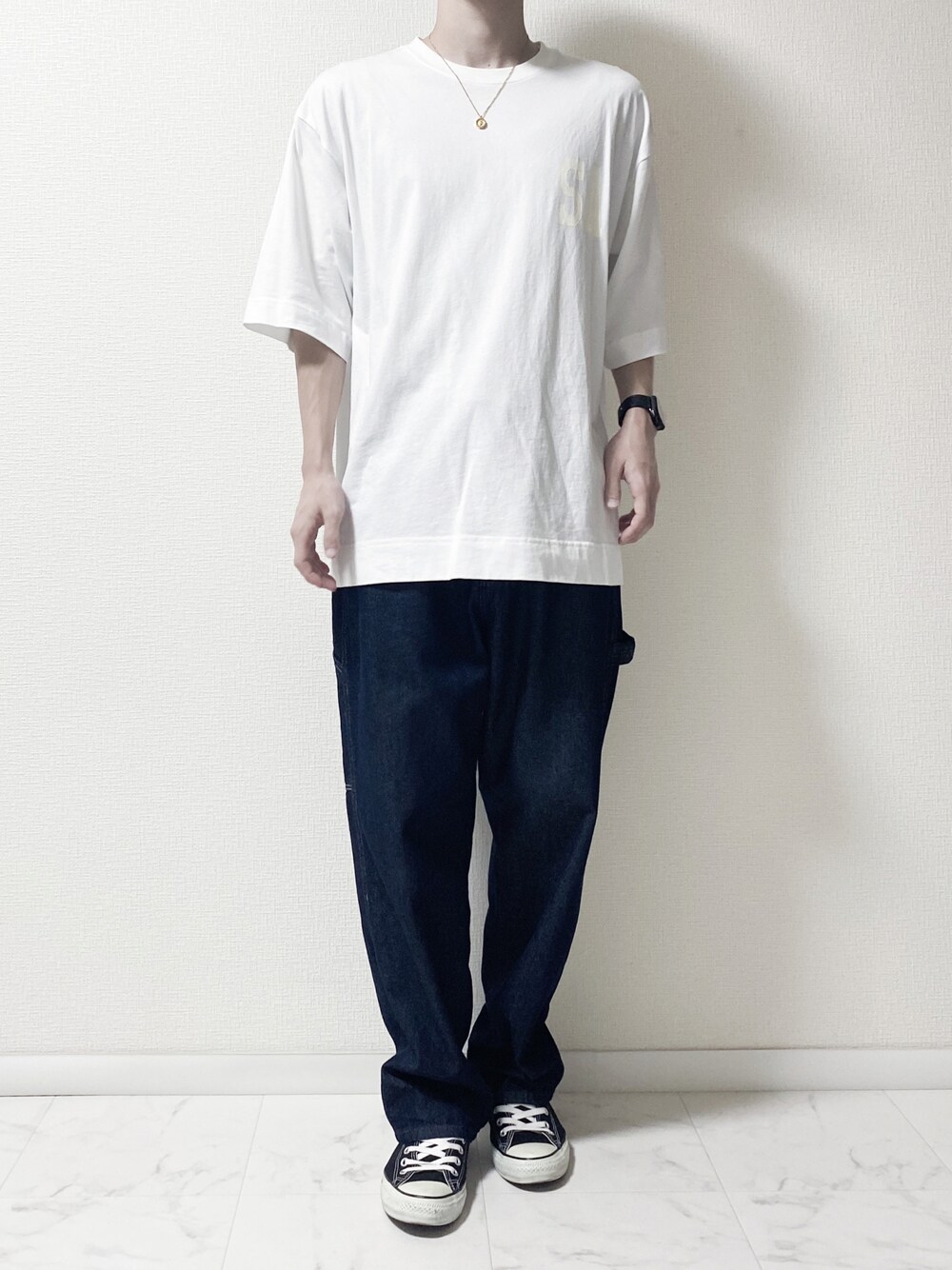 ブルー系のデニムパンツ、ホワイト系のTシャツ/カットソー、ブラック系のスニーカーを着用したメンズの秋コーディネートの1枚目の写真