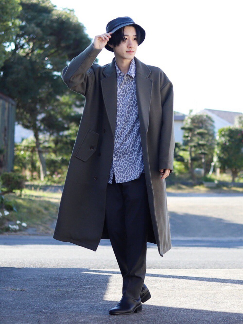 グレー系のチェスターコート、グレー系のシャツ/ブラウス、グレー系のスラックスを着用したメンズの秋コーディネートの1枚目の写真