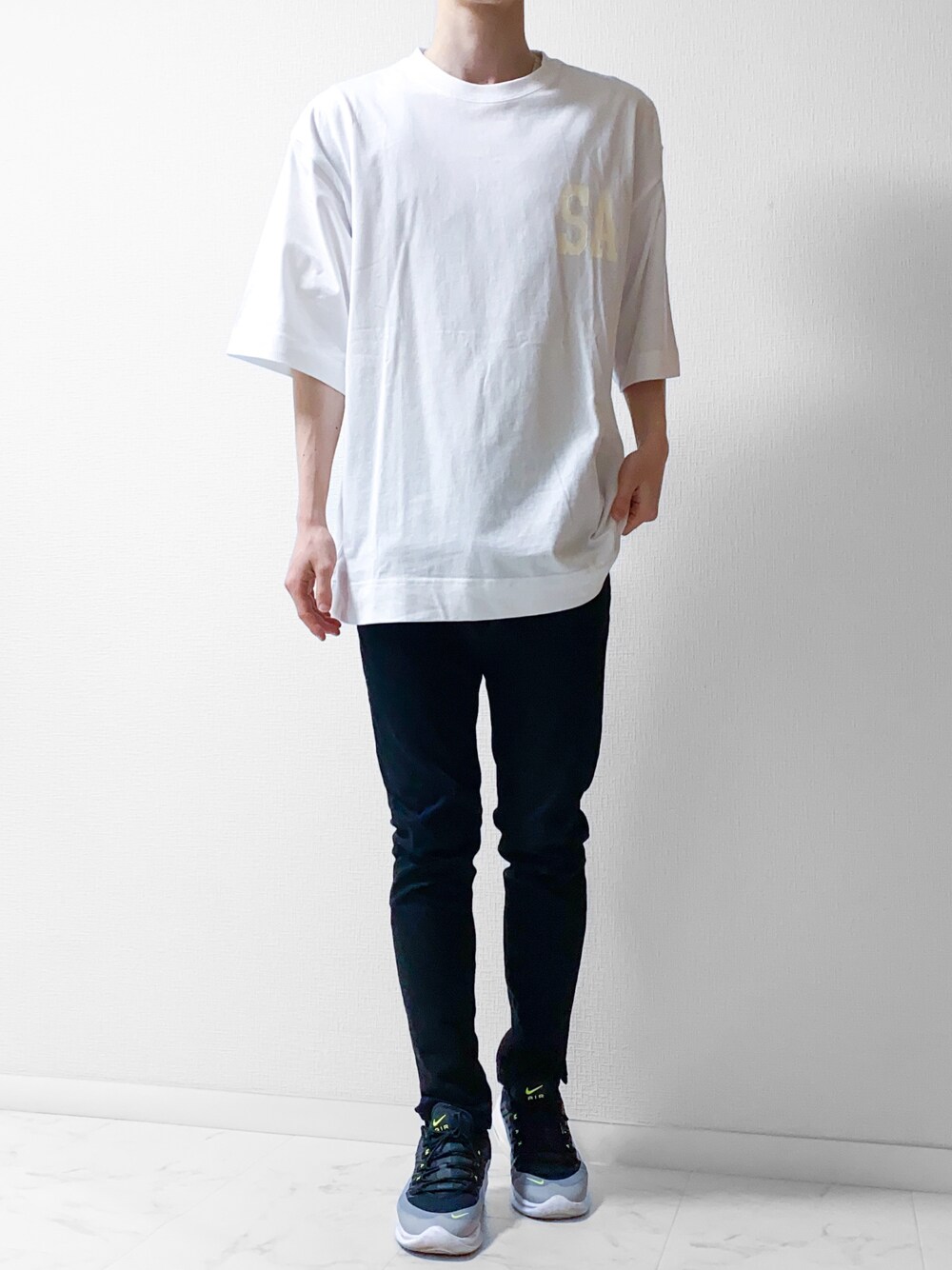 ホワイト系のTシャツ/カットソー、ブラック系のデニムパンツ、グレー系のスニーカーを着用したメンズの春コーディネートの1枚目の写真