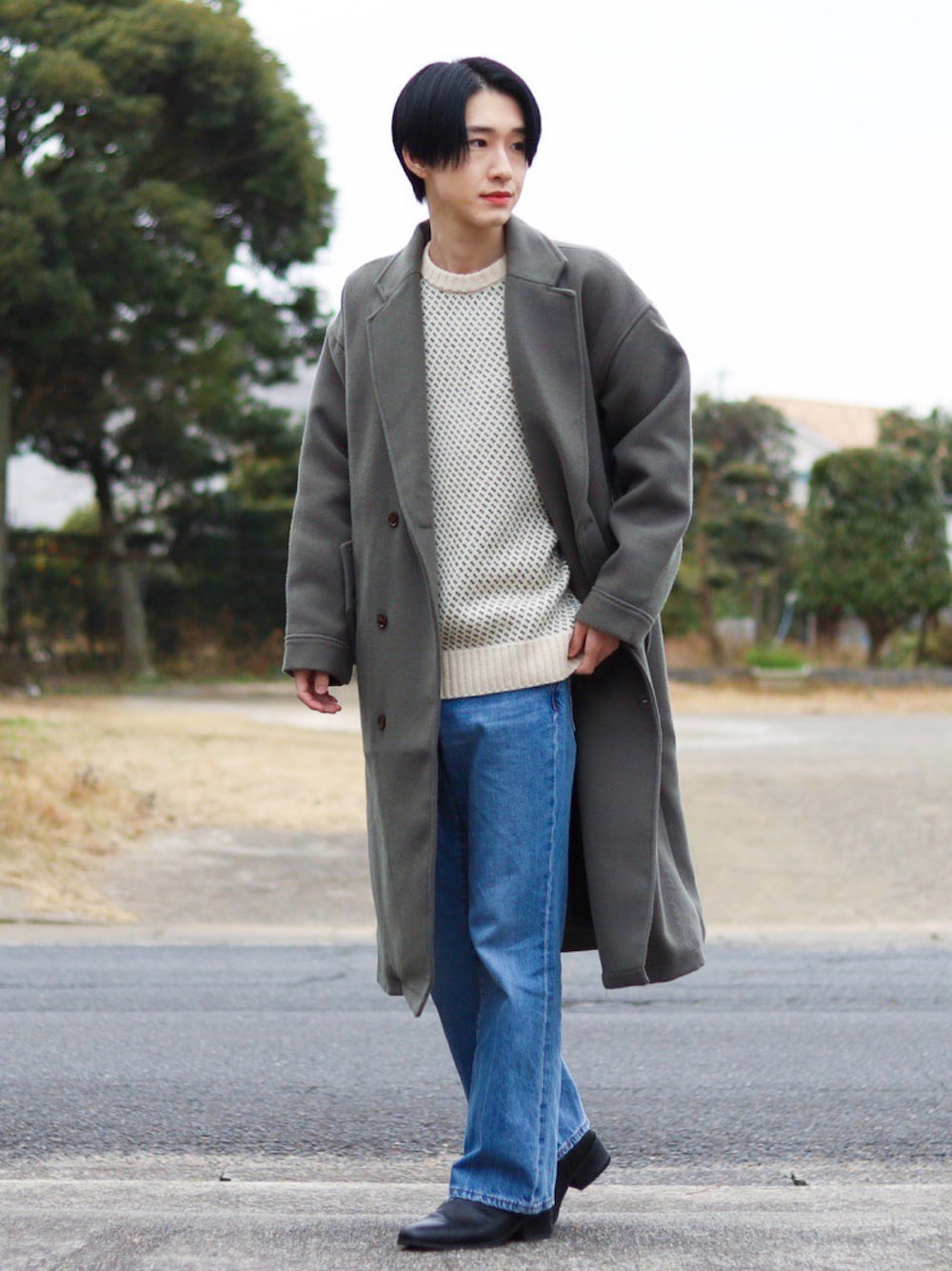 ホワイト系のニット/セーター、グレー系のチェスターコート、ブルー系のパンツを着用したメンズの冬コーディネートの1枚目の写真