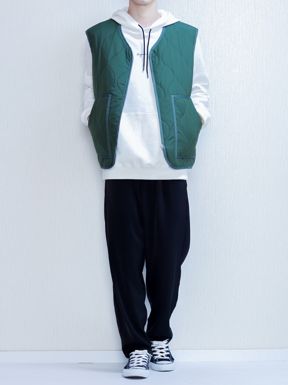 グリーン系のベスト、ホワイト系のパーカー、ブラック系のその他パンツを着用したメンズの秋コーディネートの1枚目の写真