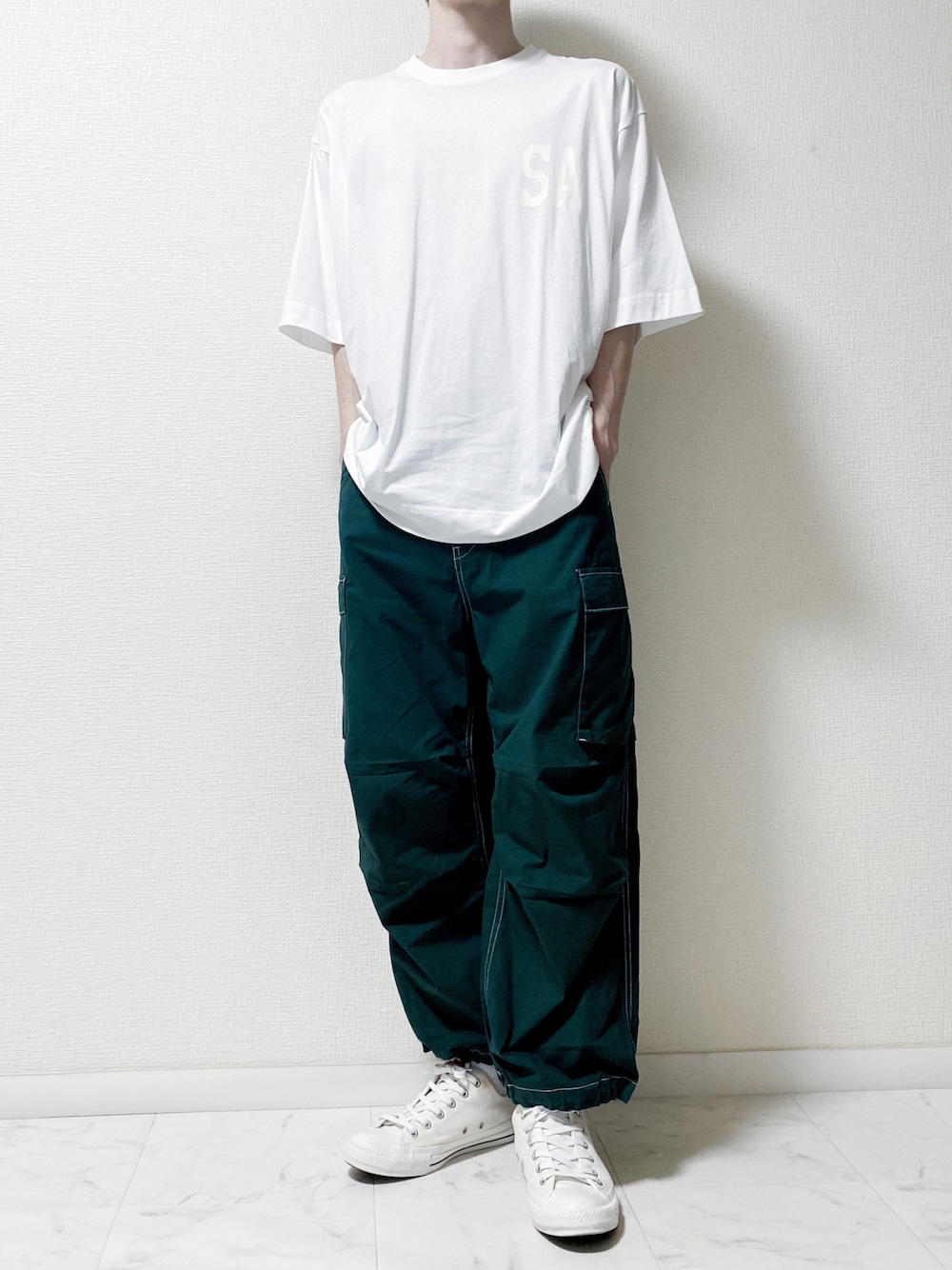 ホワイト系のTシャツ/カットソー、グリーン系のデニムパンツ、ホワイト系のスニーカーを着用したメンズの夏コーディネートの1枚目の写真