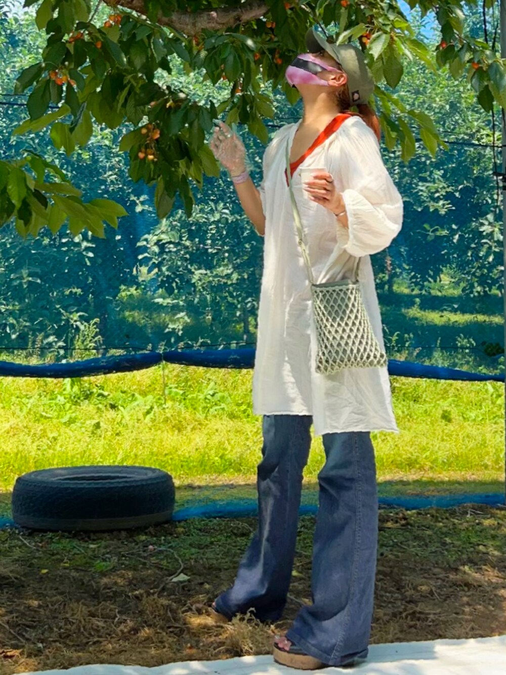 ホワイト系のワンピース/ドレス、オレンジ系のトップス、ブルー系のデニムパンツを着用したレディースの夏コーディネートの1枚目の写真