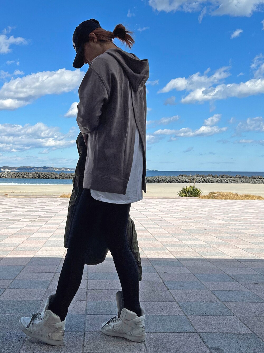 ホワイト系のスニーカー、ブラック系のデニムパンツ、ホワイト系のTシャツ/カットソーを着用したレディースの冬コーディネートの1枚目の写真
