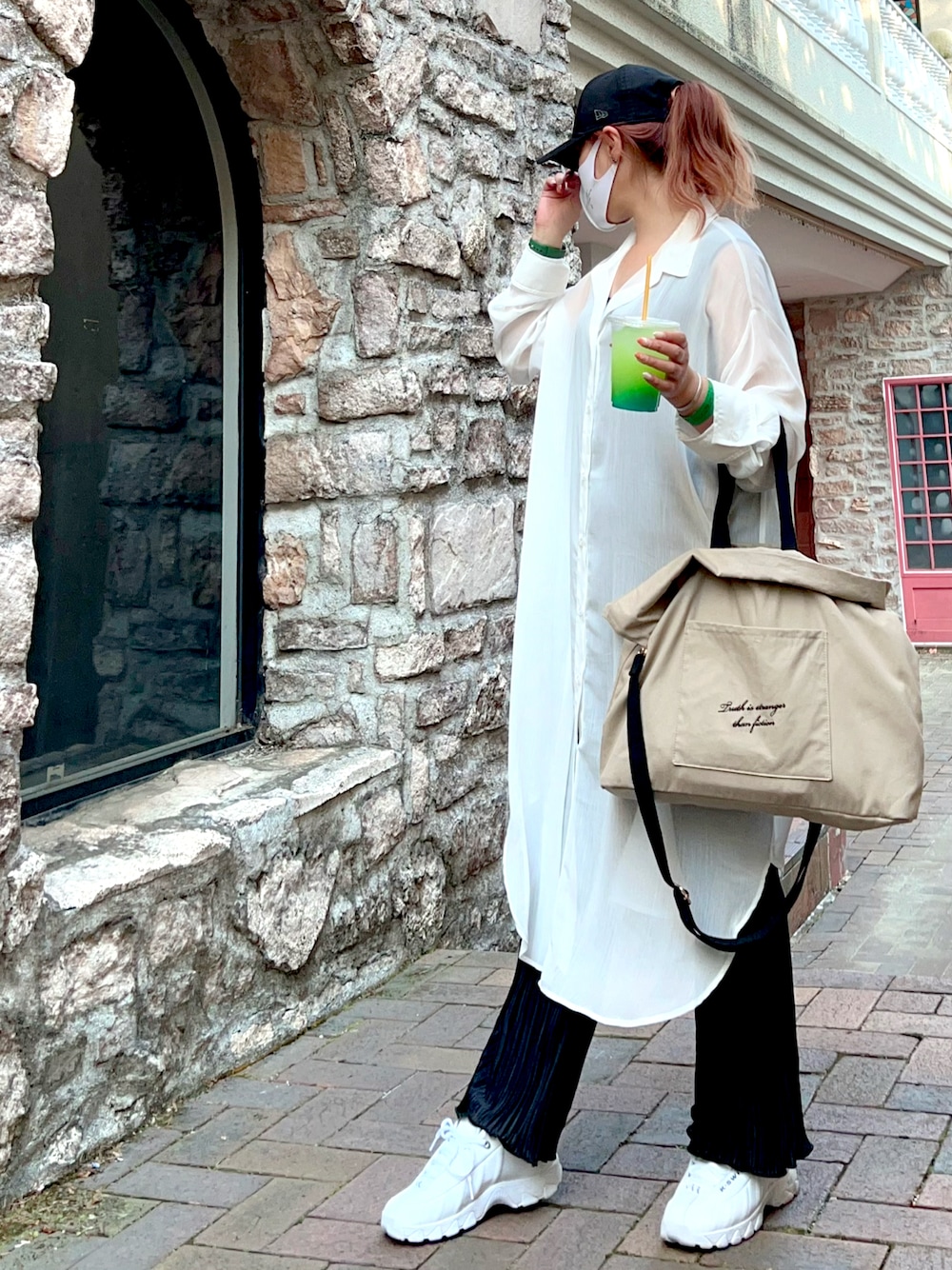 ホワイト系のシャツワンピース、ブラック系のタンクトップ、ブラック系のパンツを着用したレディースの春コーディネートの1枚目の写真