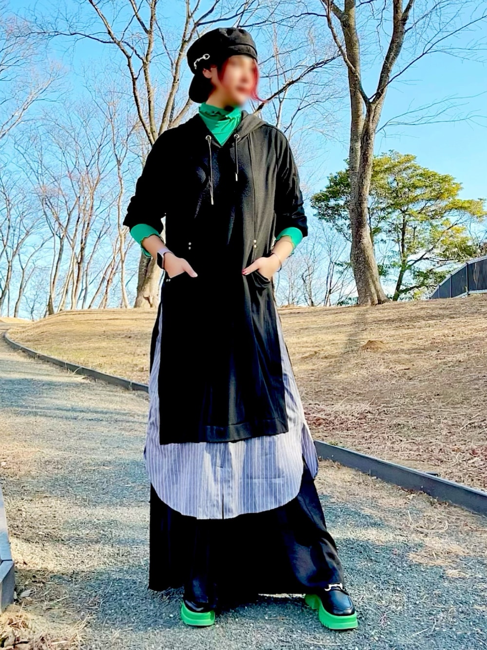 ブラック系のワンピース、ブラック系のその他パンツ、グリーン系のTシャツ/カットソーを着用したレディースの春コーディネートの1枚目の写真