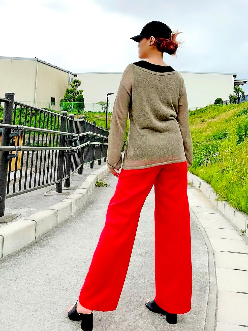 グリーン系のニット/セーター、ブラック系のタンクトップ、レッド系のスラックスを着用したレディースの春コーディネートの1枚目の写真