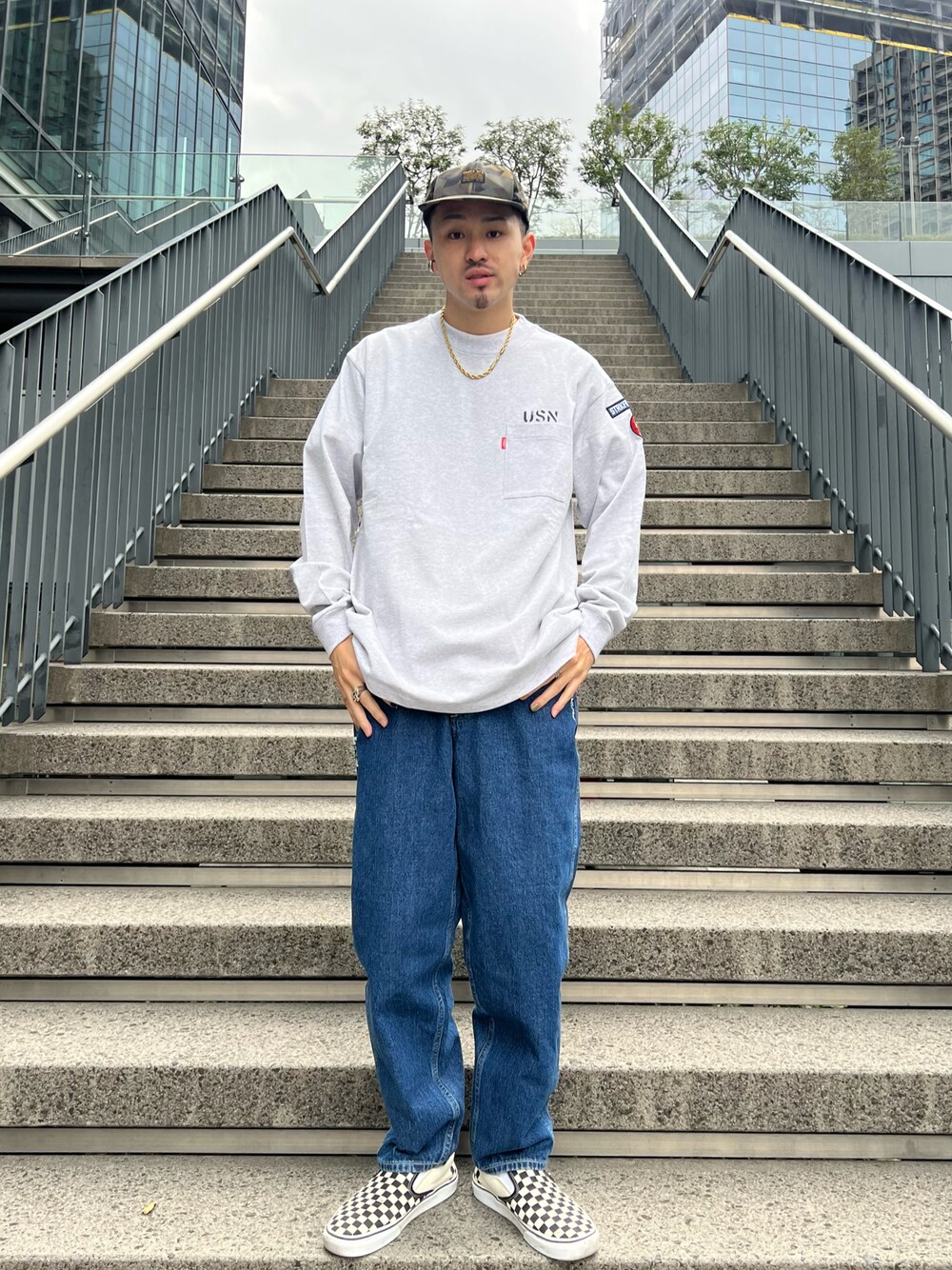 グレー系のTシャツ/カットソー、その他のデニムパンツ、ブラック系のキャップを着用したメンズの冬コーディネートの1枚目の写真