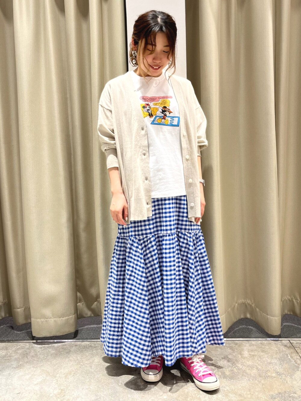 ブルー系のスカート、ホワイト系のTシャツ/カットソー、グレー系のカーディガン/ボレロを着用したレディースの春コーディネートの1枚目の写真