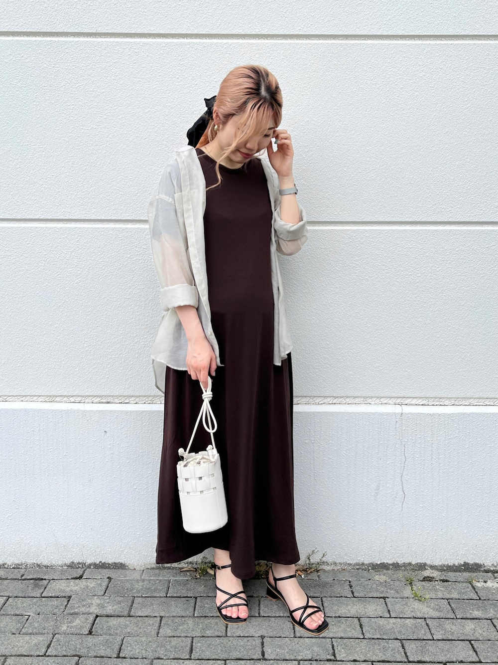 ブラウン系のワンピース、ベージュ系のシャツ/ブラウス、ブラック系のサンダルを着用したレディースの春コーディネートの1枚目の写真