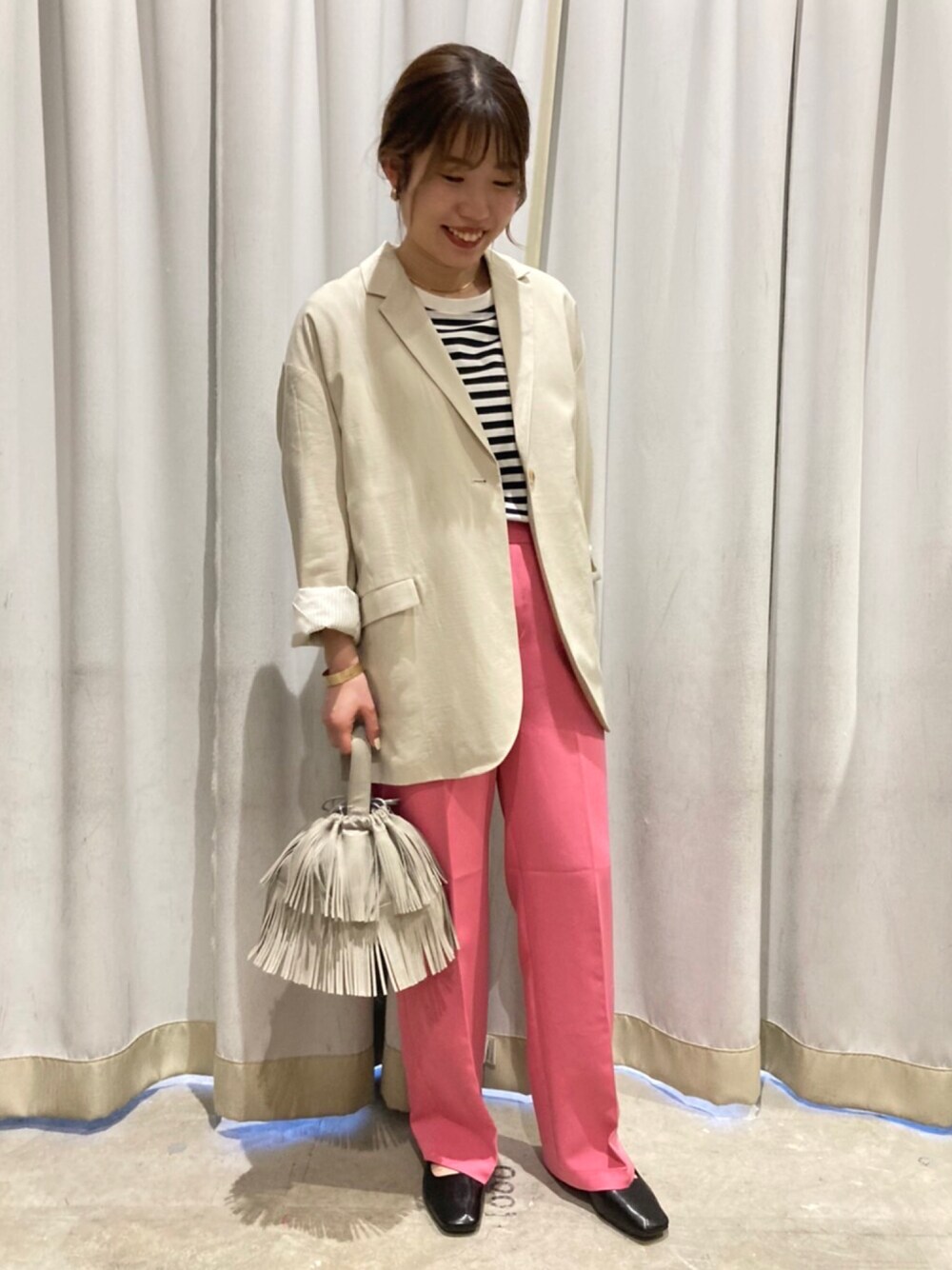 ピンク系のその他パンツ、ベージュ系のテーラードジャケット、ベージュ系のハンドバッグを着用したレディースの冬コーディネートの1枚目の写真