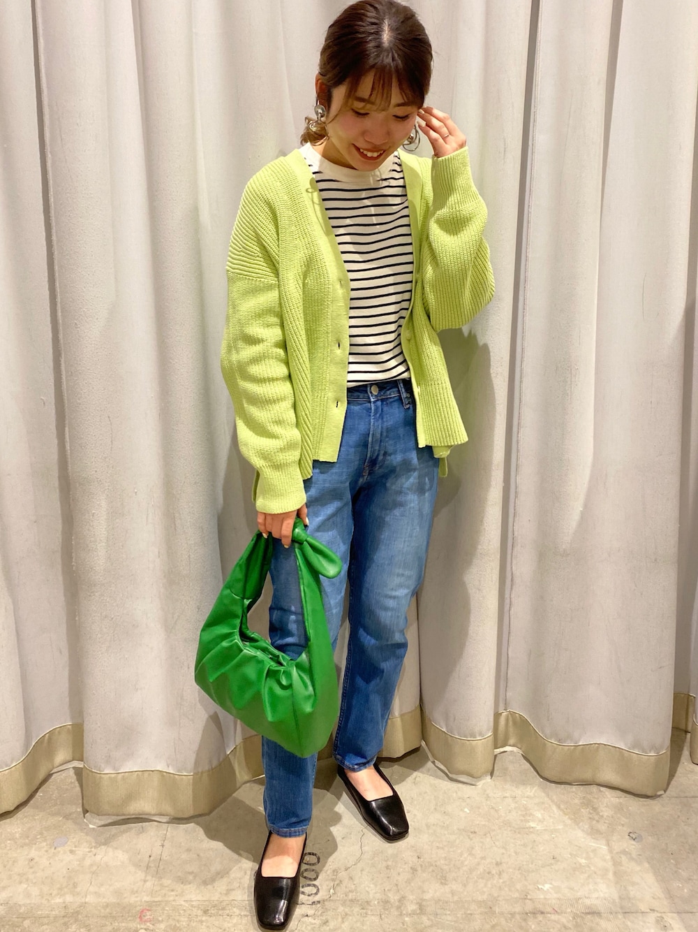 グリーン系のカーディガン/ボレロ、その他のTシャツ/カットソー、ブルー系のデニムパンツを着用したレディースの冬コーディネートの1枚目の写真