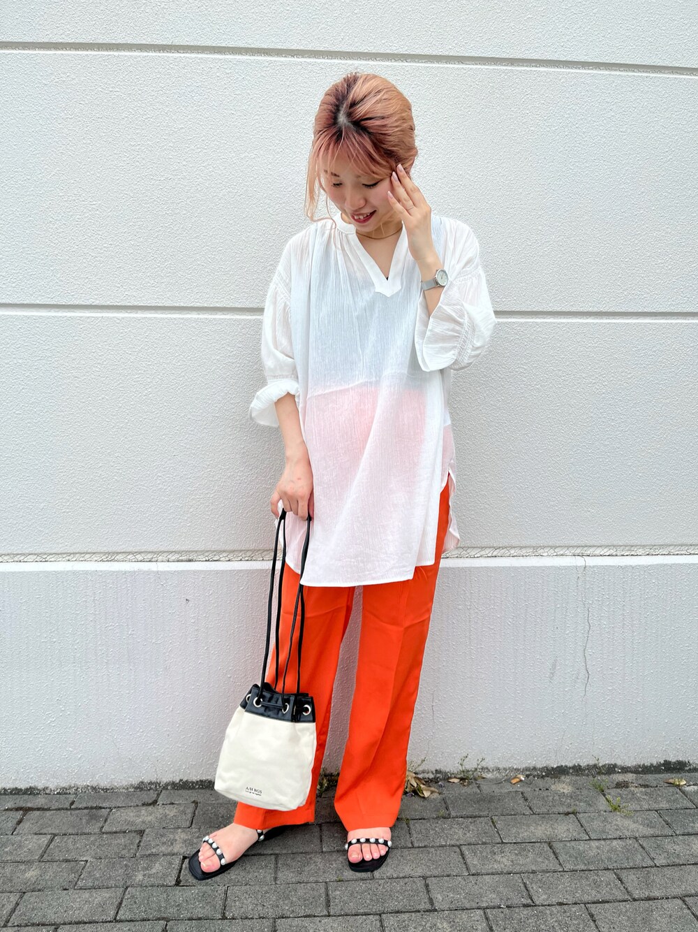 ホワイト系のシャツ/ブラウス、オレンジ系のスラックス、ブラック系のサンダルを着用したレディースの春コーディネートの1枚目の写真