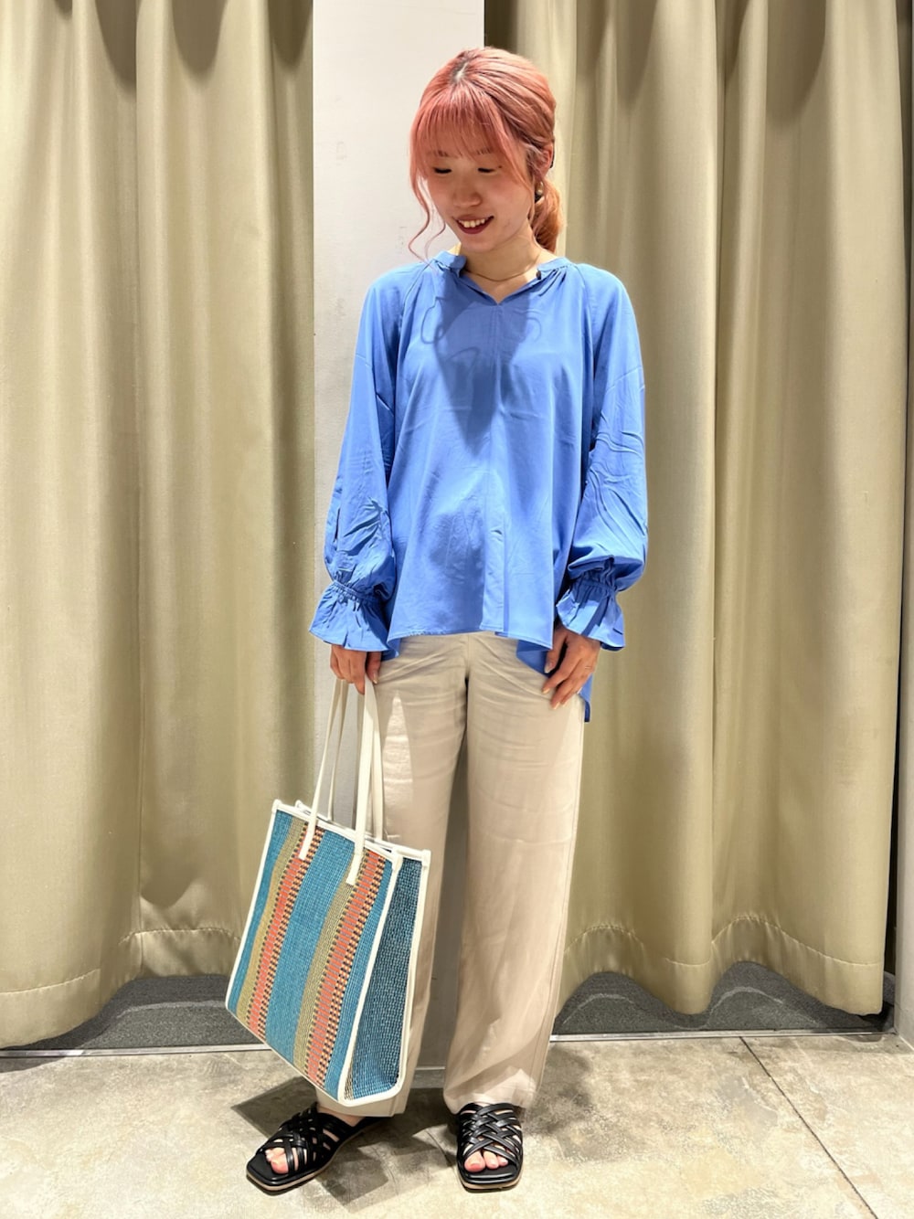 ブルー系のシャツ/ブラウス、ブルー系のトートバッグ、ブラック系のサンダルを着用したレディースの春コーディネートの1枚目の写真