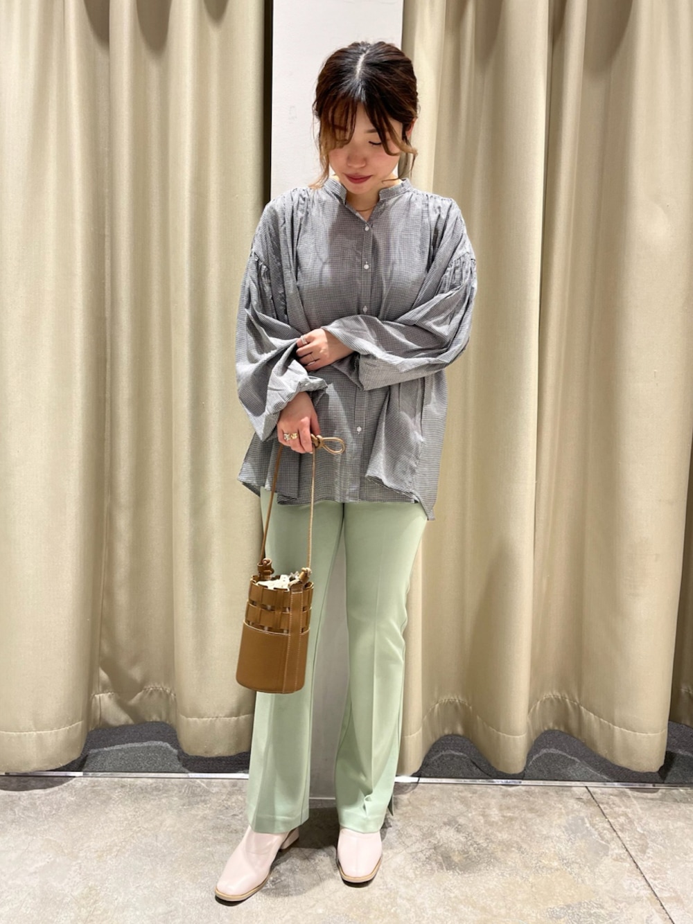 ブラウン系のショルダーバッグ、ホワイト系のブーツ、グリーン系のその他パンツを着用したレディースの春コーディネートの1枚目の写真