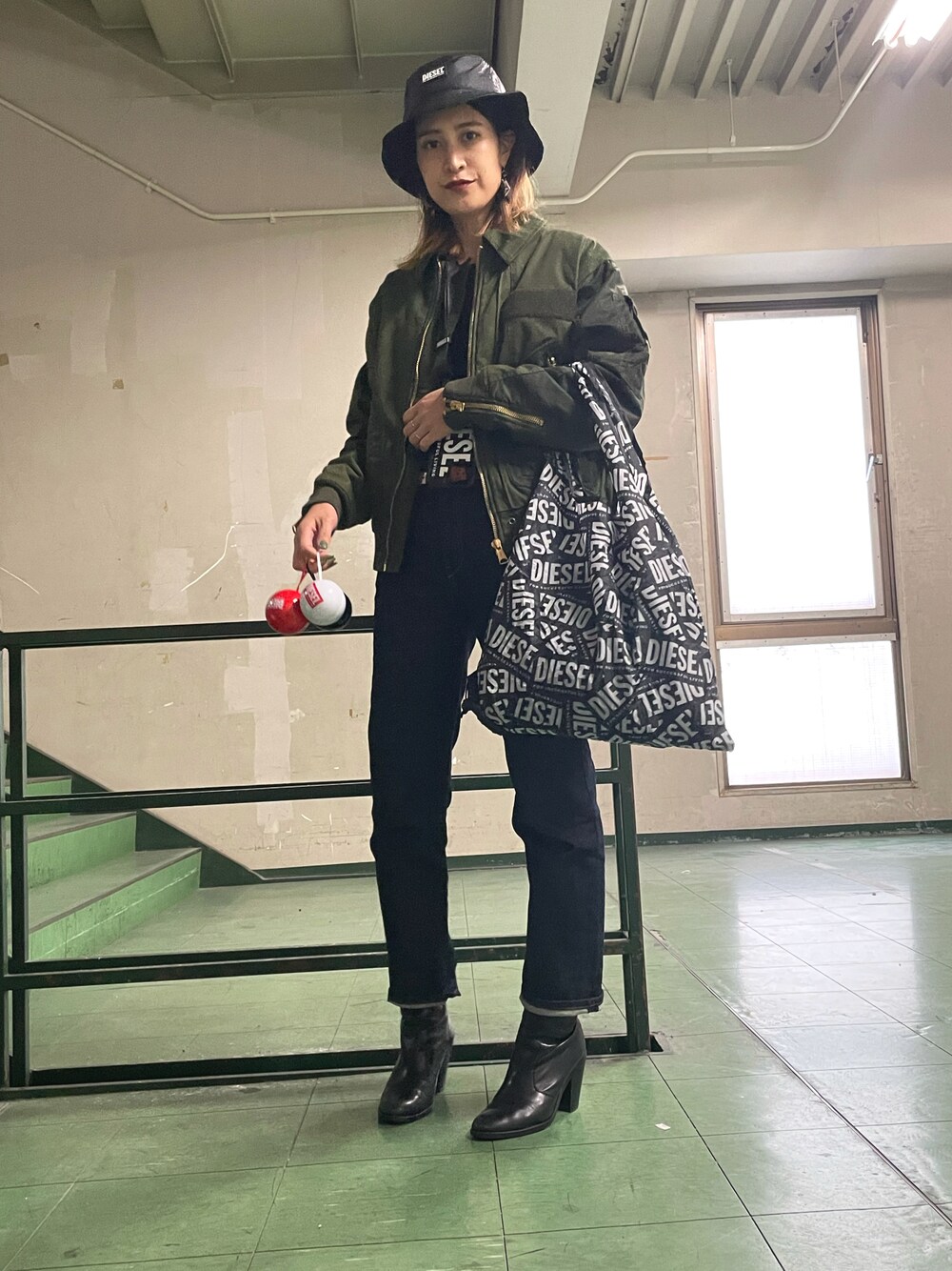 グリーン系のジャケット/アウター、ブルー系のデニムパンツ、ブラック系のハットを着用したレディースの秋コーディネートの1枚目の写真
