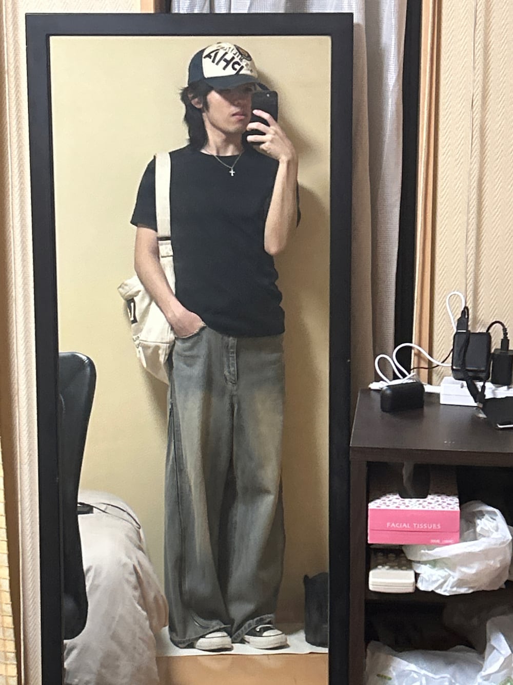 ブラック系のスニーカー、ブルー系のデニムパンツ、ブラック系のTシャツ/カットソーを着用したメンズの秋コーディネートの1枚目の写真