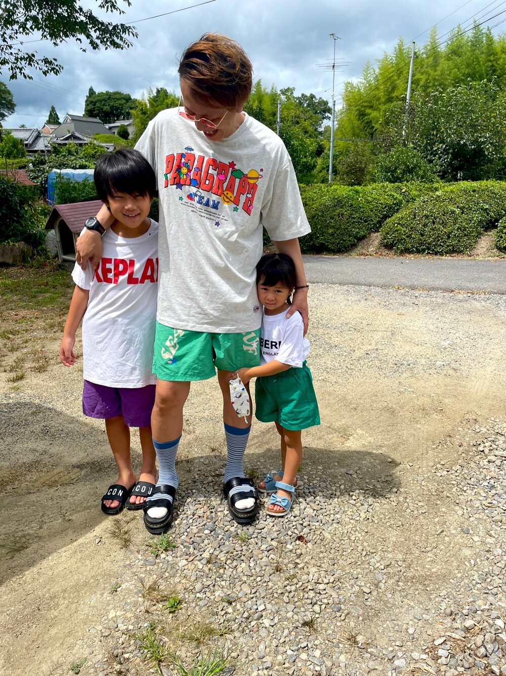 グレー系のTシャツ/カットソー、グリーン系のパンツ、ブラック系のサンダルを着用したメンズの夏コーディネートの1枚目の写真
