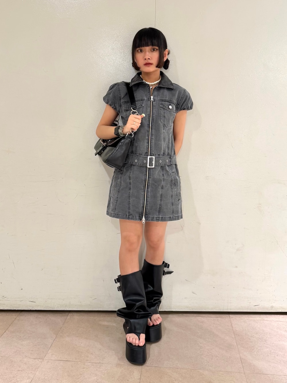 ブラック系のハンドバッグ、ブラック系のワンピース、ブラック系のサンダルを着用したレディースの夏コーディネートの1枚目の写真