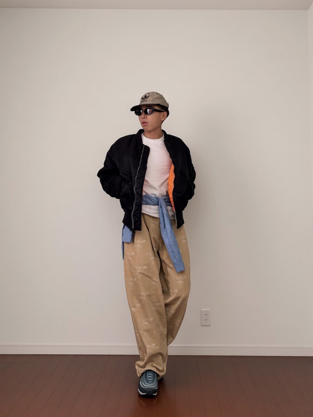 ホワイト系のTシャツ/カットソー、ブルー系のスニーカー、ブルー系のニット/セーターを着用したメンズの秋コーディネートの1枚目の写真