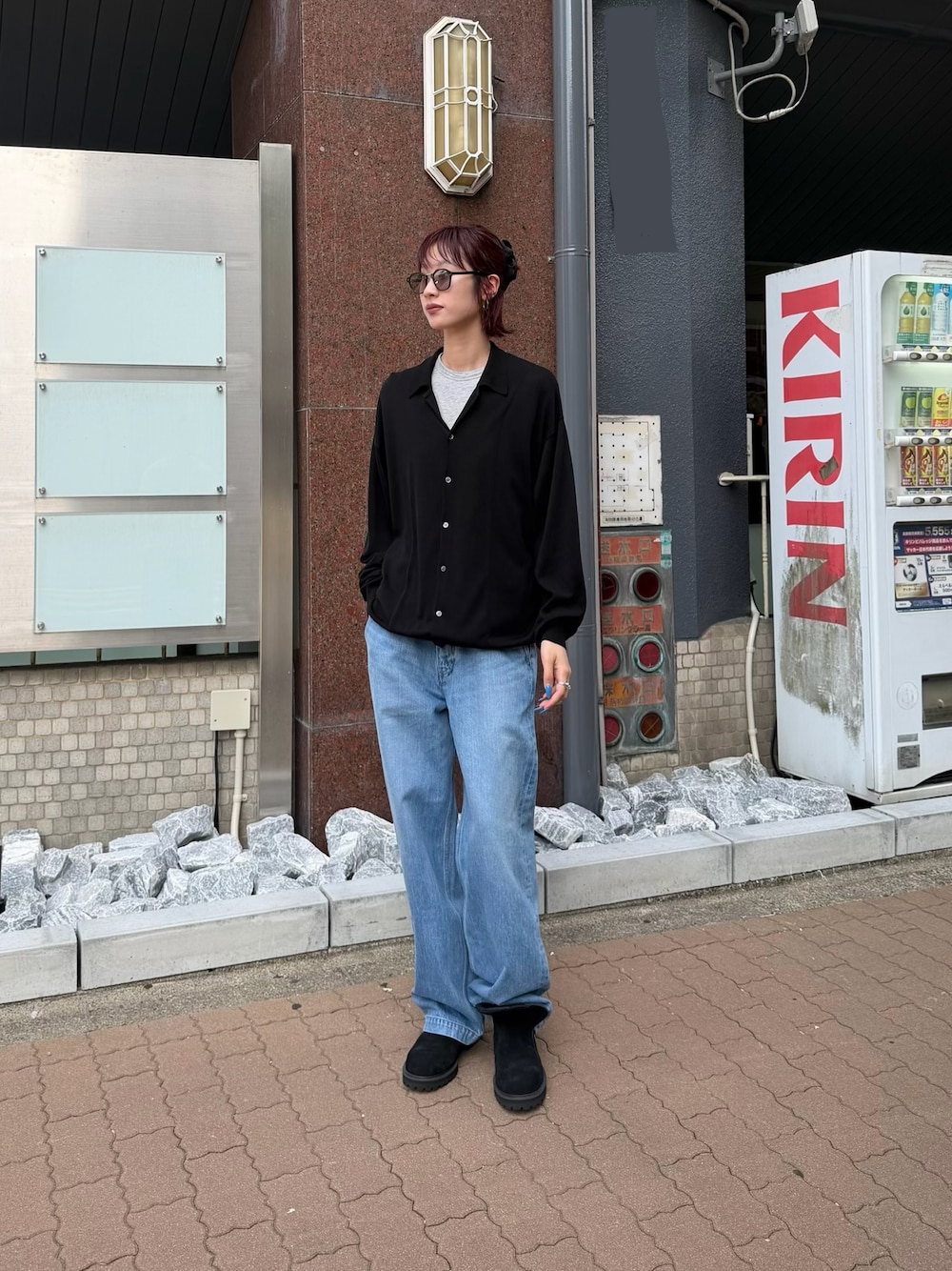 ブラック系のニット/セーター、ブルー系のデニムパンツ、ブラック系のブーツを着用したレディースの夏コーディネートの1枚目の写真